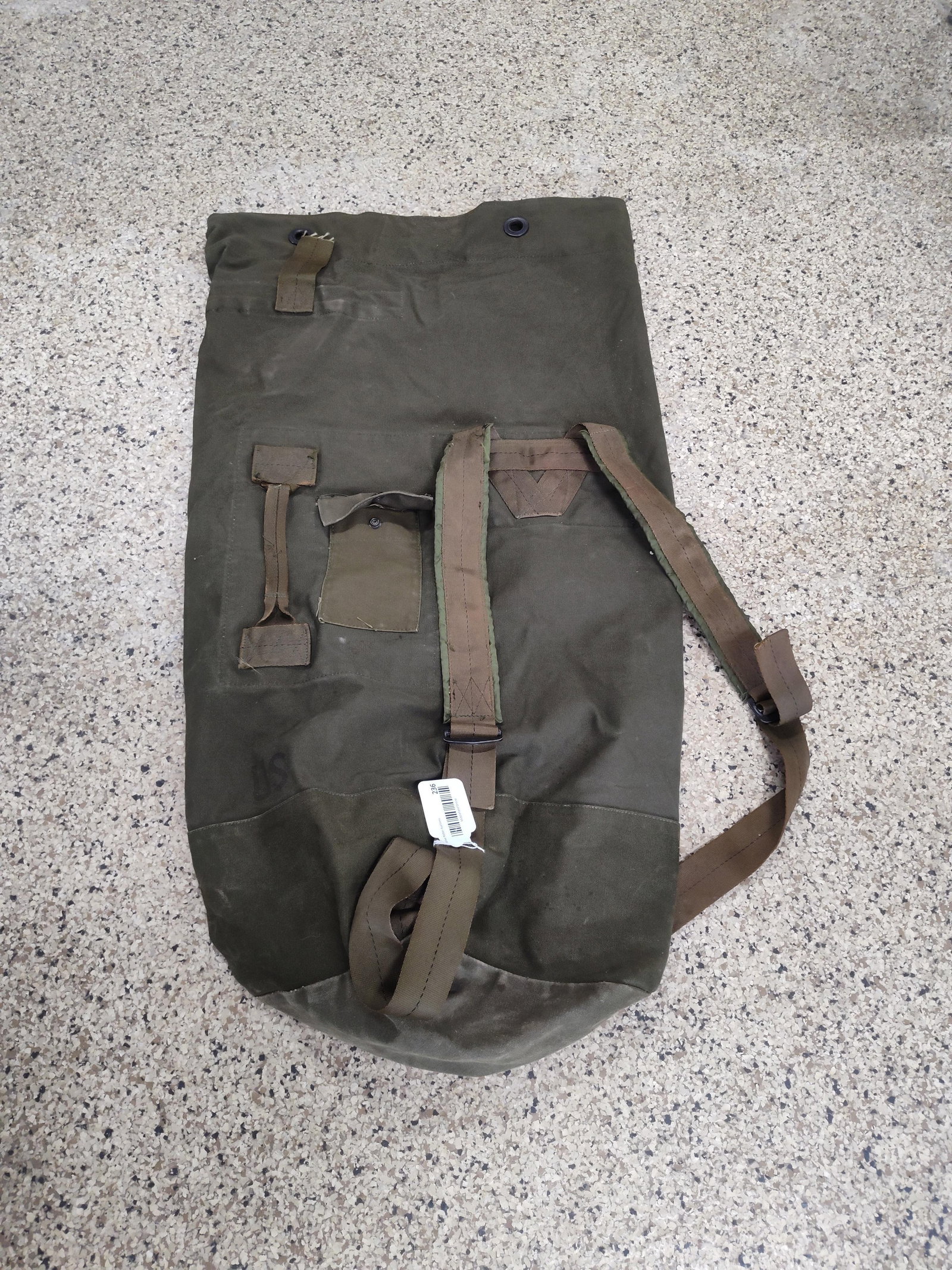 US Military Type I Canvas Duffel, 1984: This is a United States military issue Type I duffel bag, also known as a sea bag, constructed from heavyweight olive drab canvas with nylon webbing straps. The design includes two adjustable padded s