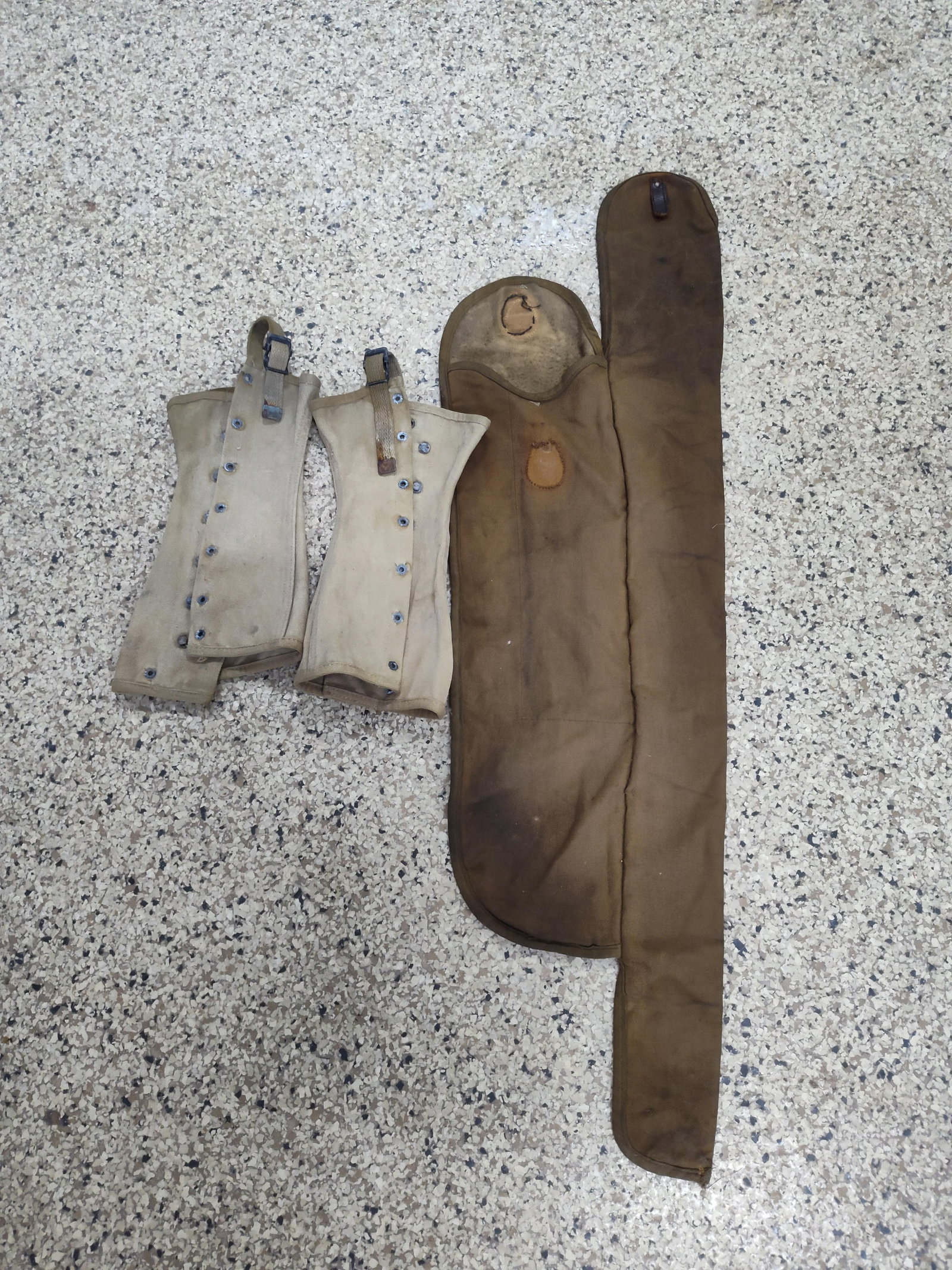 US Military WWII Canvas Field Equipment: This group consists of three pieces of WWII-era United States military canvas field equipment: a pair of M1938 dismounted leggings and a M1918A2 Browning Automatic Rifle (BAR) spare barrel and tool ca