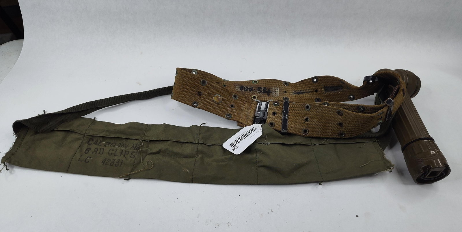 US M1936 Belt, Bandoleer & Flashlight: This lot features three pieces of authentic United States military field equipment. The first item is an M1936 pattern pistol belt constructed of heavy-duty woven cotton canvas in Olive Drab No. 3 (kh