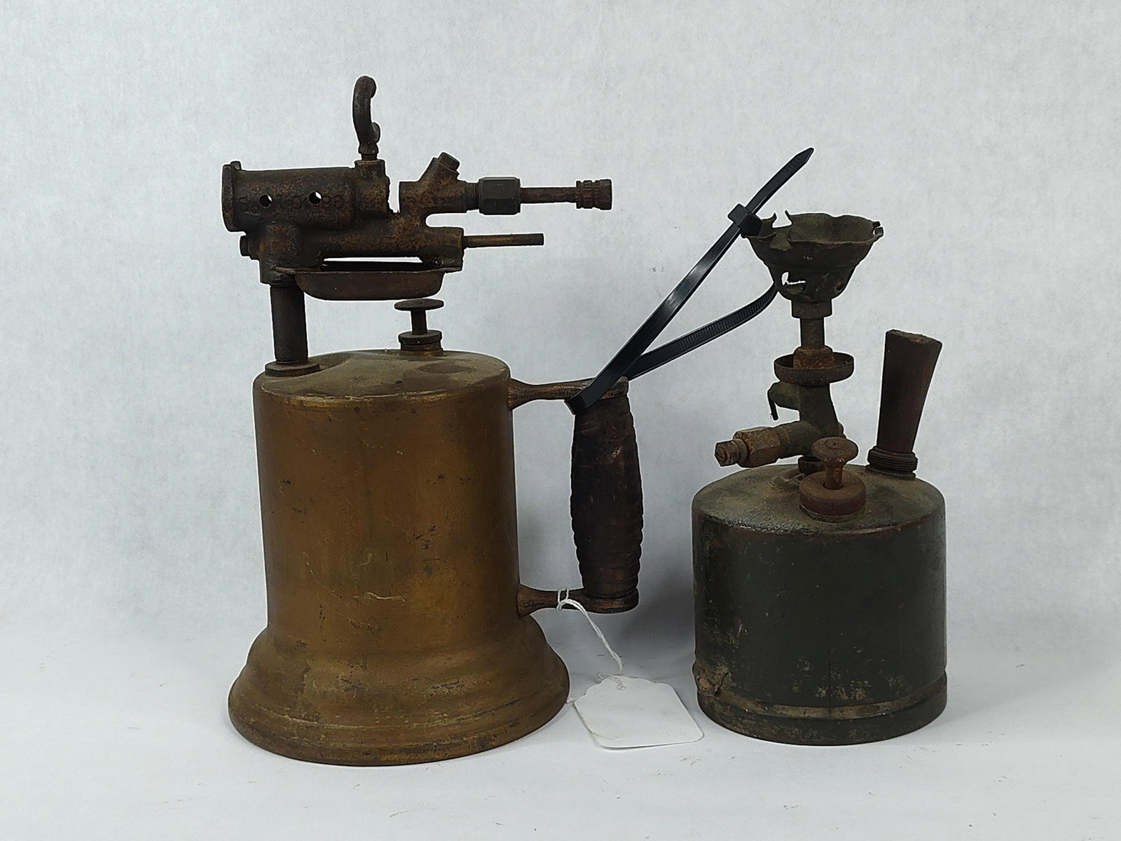 Pair Clayton & Lambert S45 Blowtorches: This offering consists of two antique liquid fuel blowtorches, manufactured in the early to mid-20th century. The larger unit is a Clayton and Lambert Manufacturing Company Model S45 blowtorch. This