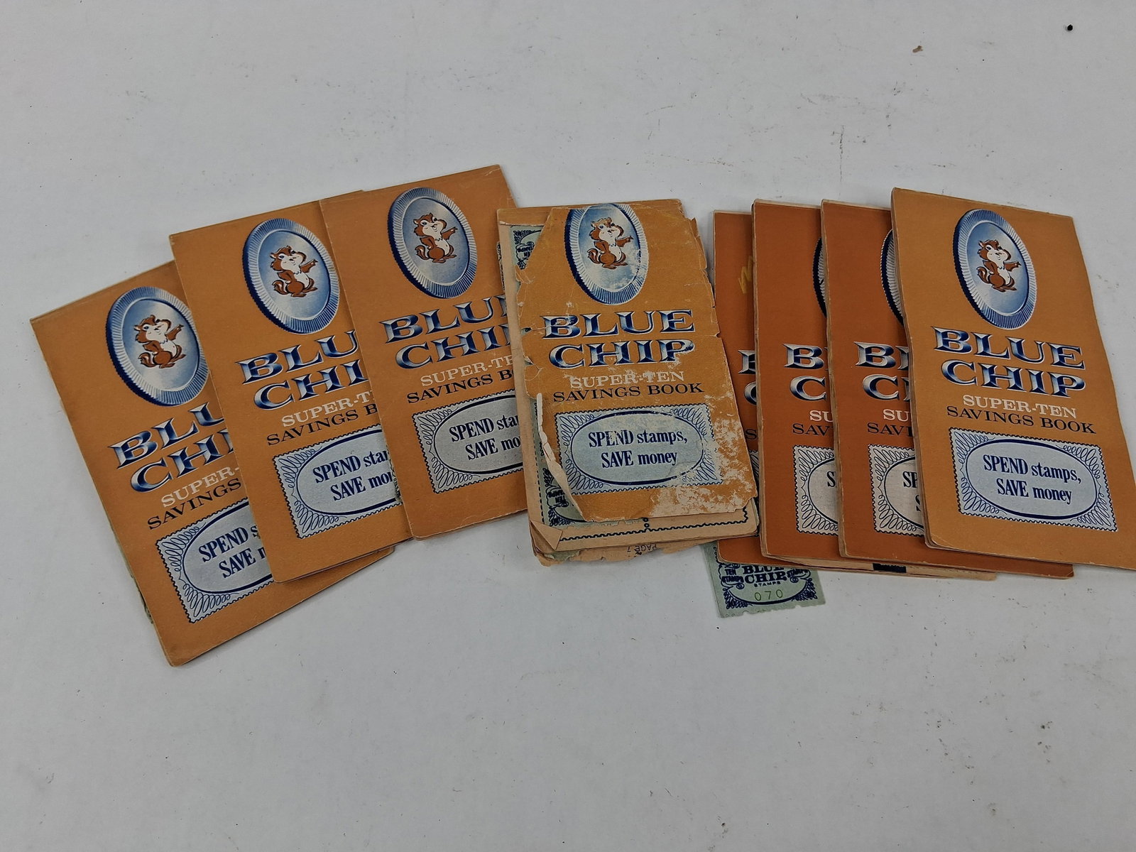 9 Blue Chip Super-Ten Books & Stamp: This lot features retail loyalty program ephemera from the Blue Chip Stamp Company, a prominent brand in the Western United States during the mid-20th century. The collection consists of nine Super-Te