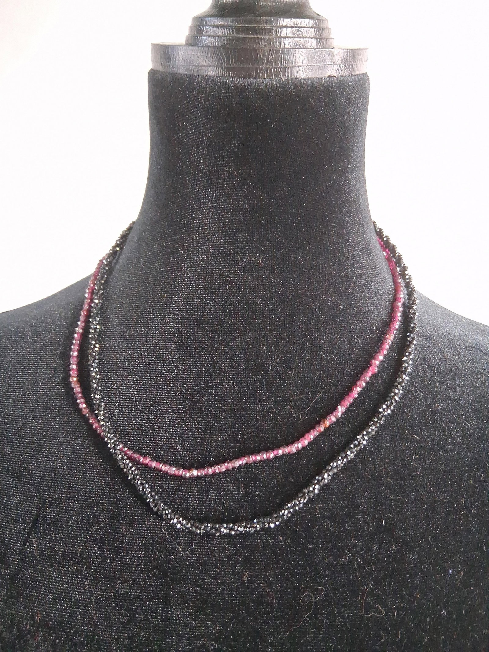 Pair Rhodolite & Spinel Str. Necklaces: A pair of individual single-strand necklaces featuring micro-faceted gemstone beads. One strand consists of transparent reddish-purple rondelle beads, consistent in appearance with rhodolite garnet. T