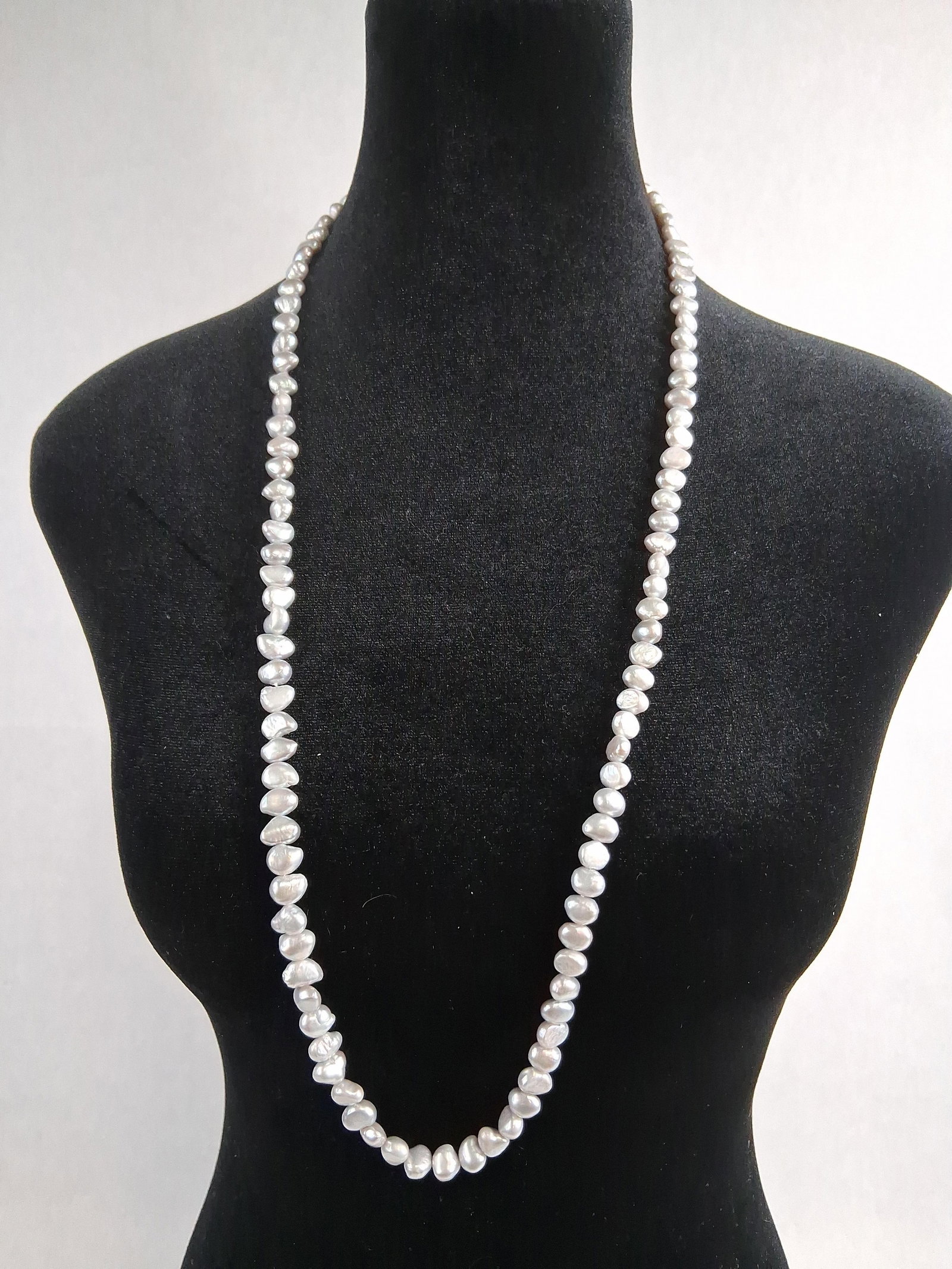 Baroque Pearl Rope Necklace w/ 14K Gold: A long rope-length necklace featuring a continuous strand of cultured freshwater baroque pearls. The pearls are characterized by an irregular potato shape and a silvery gray body color with soft