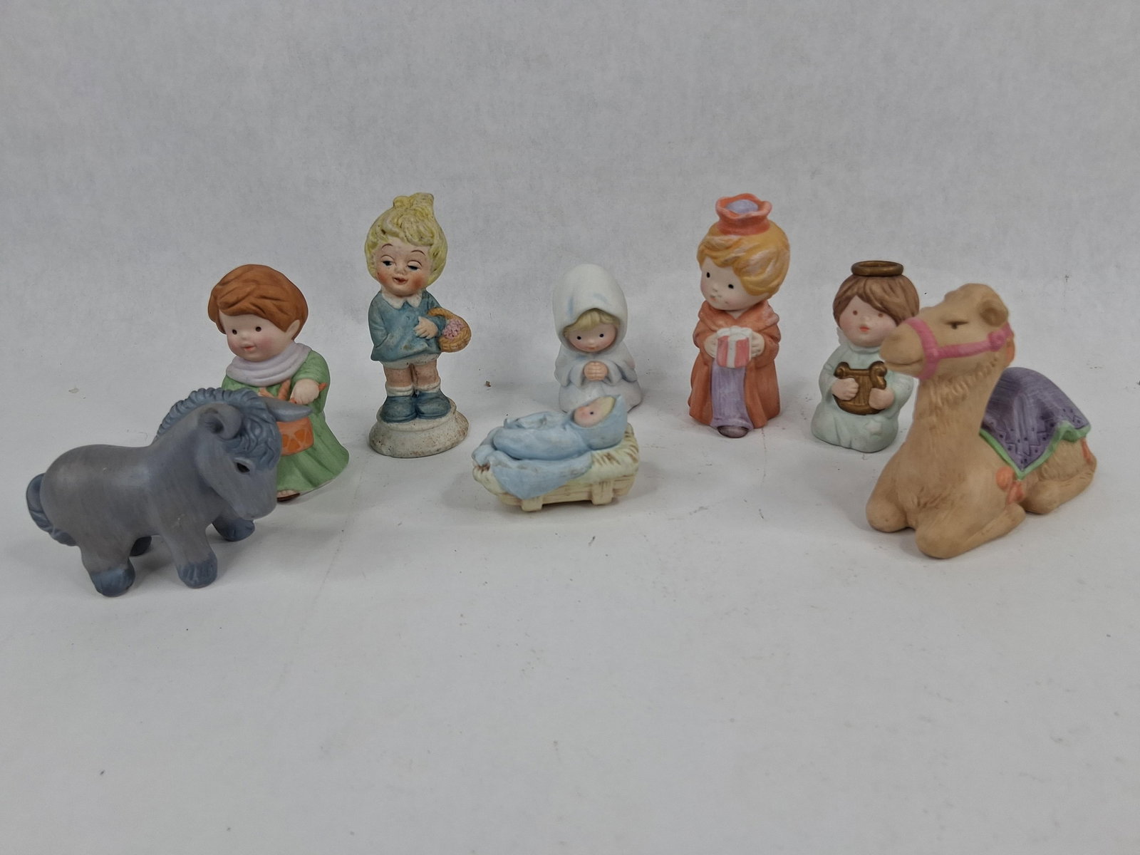 Avon 1986 Porcelain Nativity Set: This eight-piece Nativity collection is from the Avon Heavenly Blessings series, manufactured in 1986. The figurines are made of hand-painted bisque porcelain with a matte finish and a pastel color pa