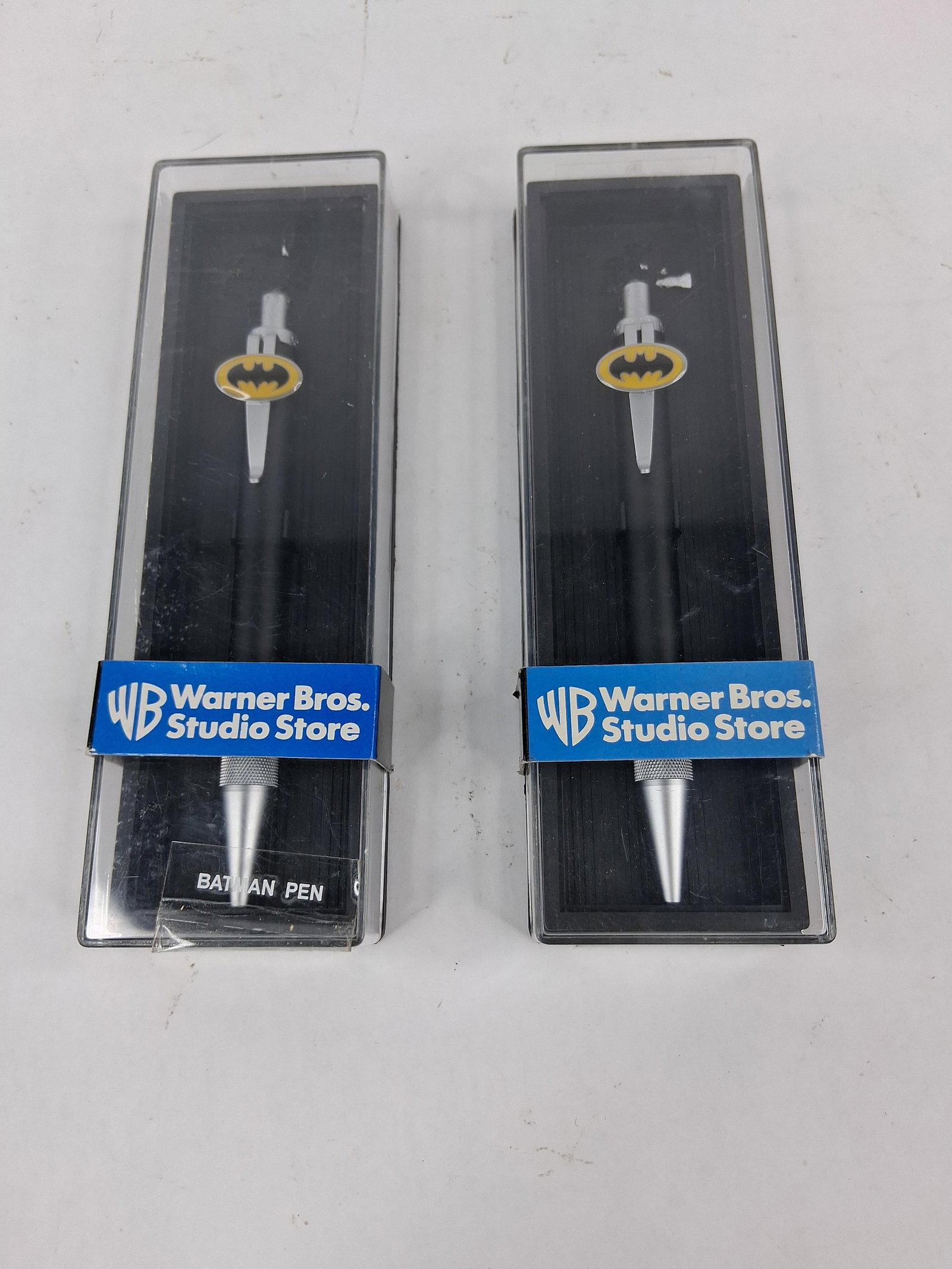 Pair Warner Bros. Studio Batman Pens: This lot features a pair of Batman-themed collectible pens, originally retailed through the Warner Bros. Studio Store circa 1999. Each pen is constructed with a matte black barrel and features a chrom