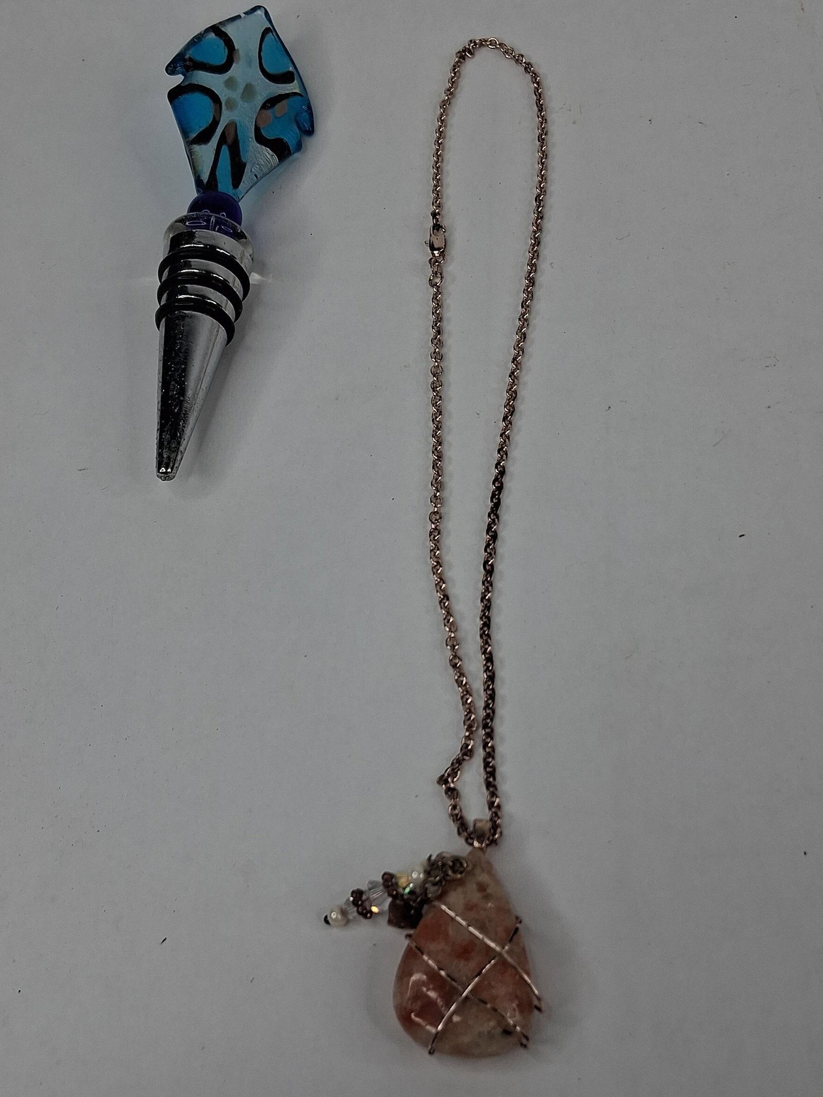 Lampwork Stopper & Sunstone Necklace: This lot includes two decorative items consisting of a glass bottle stopper and a gemstone pendant necklace. The bottle stopper features a topper crafted from lampwork glass in a stylized multi-pointe