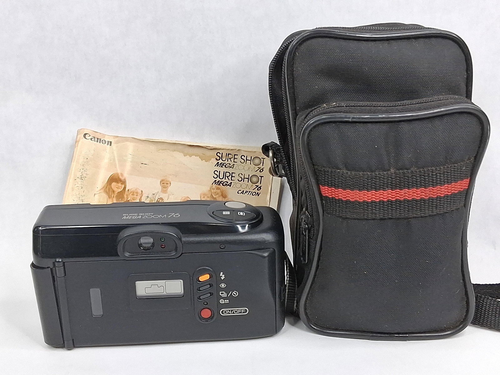 Canon Sure Shot Mega Zoom 76 Camera Kit: This lot features a Canon Sure Shot Mega Zoom 76, a 35mm autofocus point and shoot film camera. The camera is equipped with a Canon 38-76mm f/3.8-7.2 power zoom lens. The body is constructed from blac