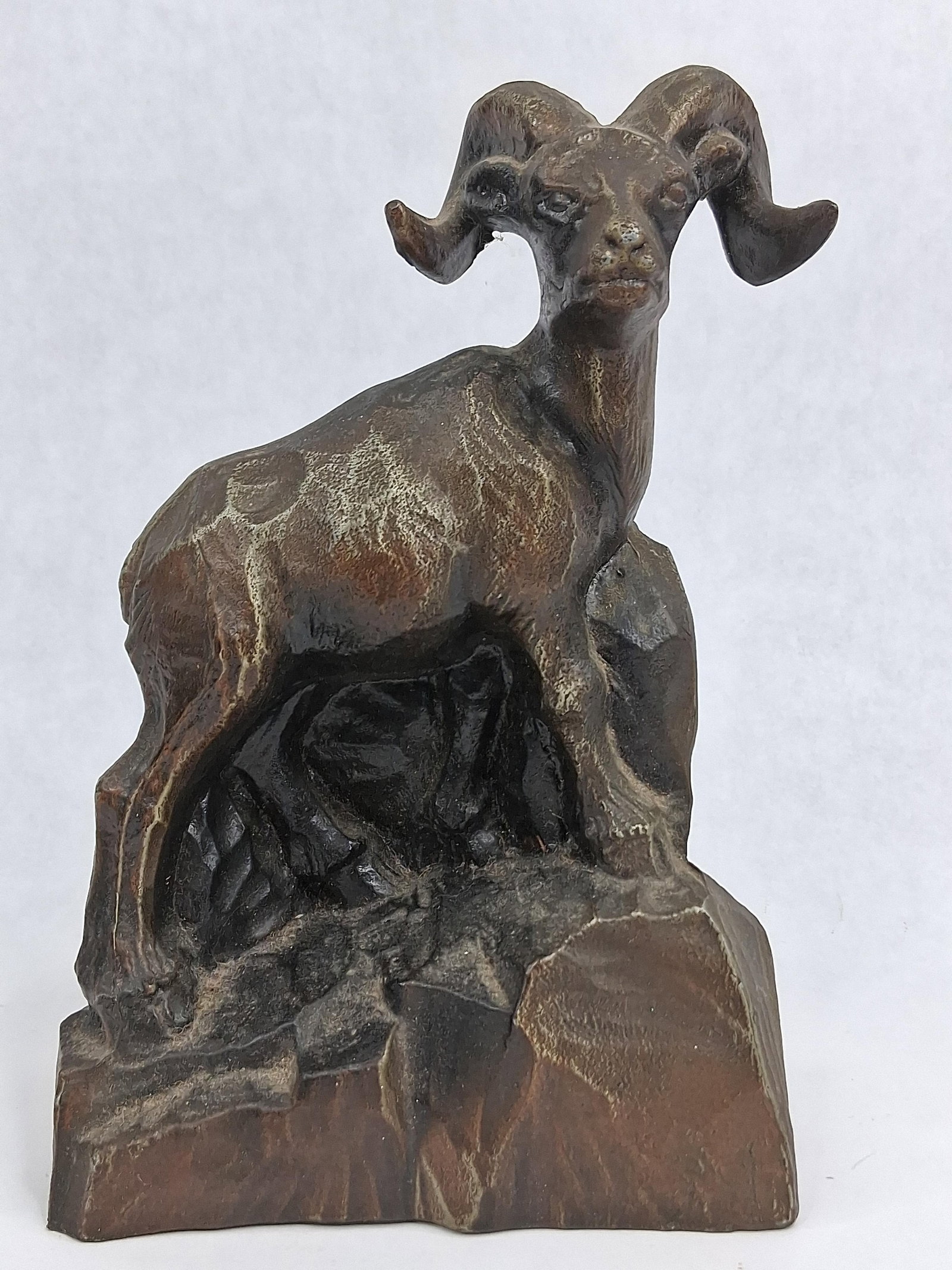 Banthrico Cast Metal Bighorn Sheep Bank: This cast metal savings bank, produced by Banthrico Inc., depicts a bighorn sheep or ram standing atop a rocky outcrop. The figurine is cast from a zinc alloy, commonly referred to as spelter, and fin
