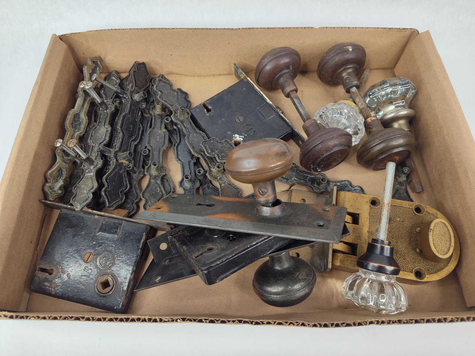 Penn Hardware & Victorian Door Hardware: This lot comprises a collection of late 19th to early 20th-century architectural door and cabinet hardware. The assortment features multiple surface-mounted cast iron rim locks, including one example 