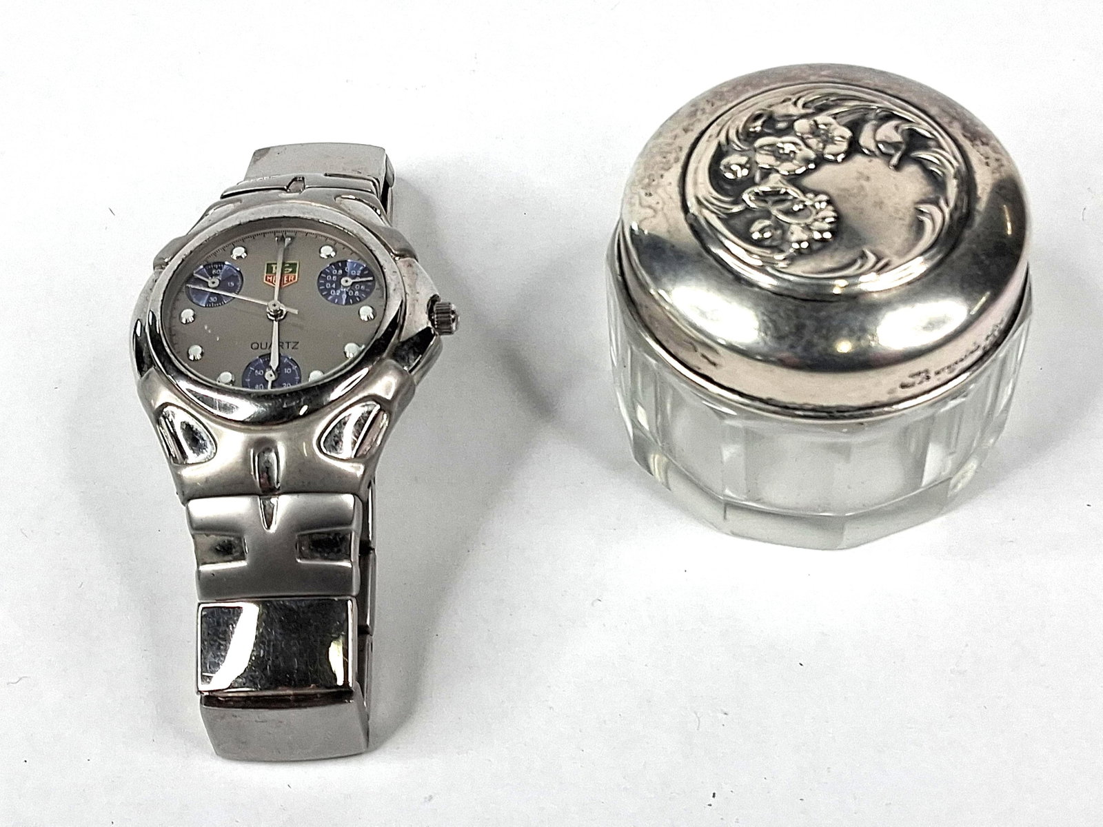 Gorham Str. Vanity Jar & Chronograph: A late 19th-century vanity jar by Gorham Manufacturing Company featuring a clear faceted glass body and an ornate sterling silver lid. The lid is decorated with repouss? floral Art Nouveau motifs and 