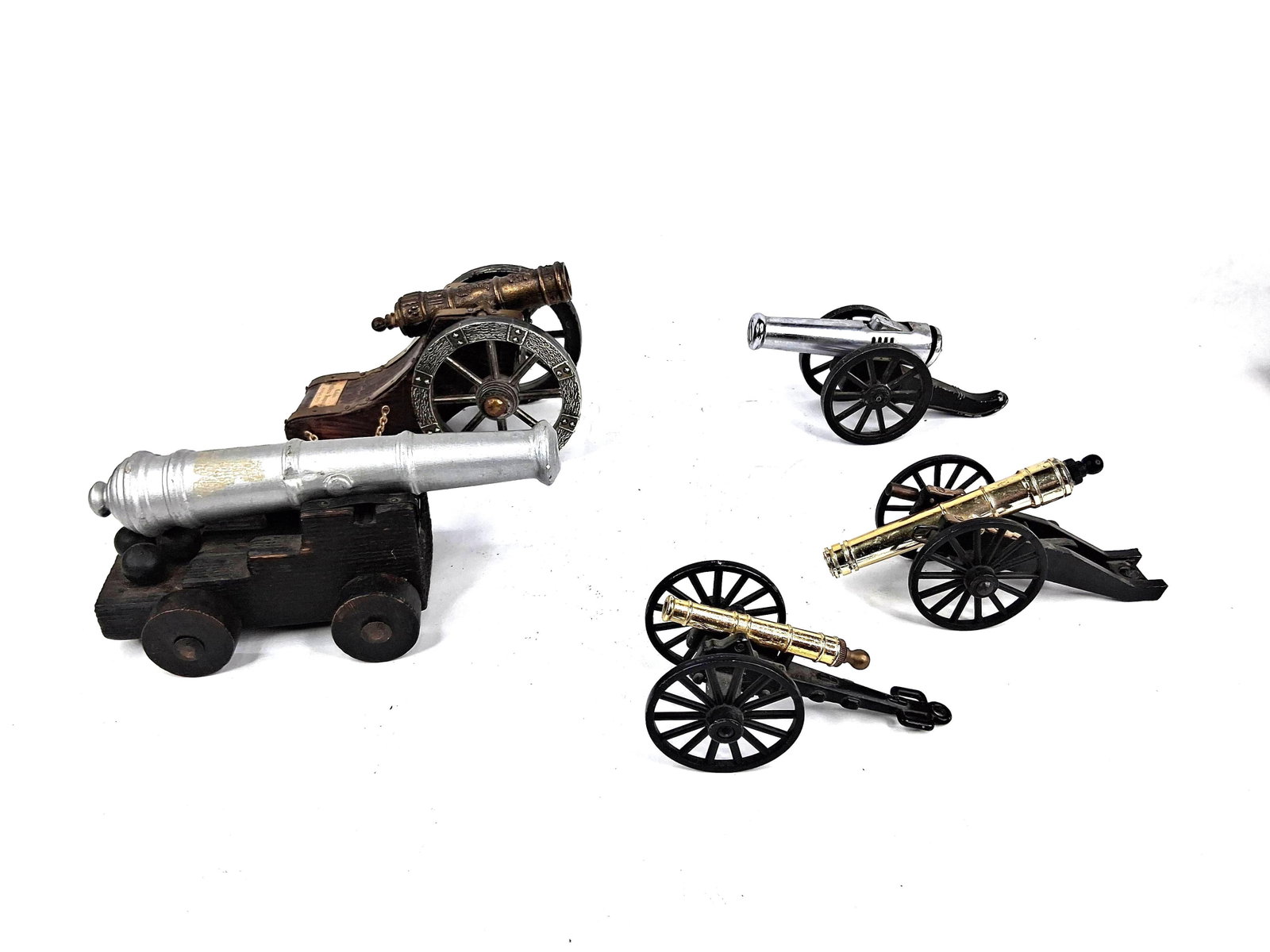 5 Miniature Model Cannons & Lighter: This collection consists of five decorative miniature model cannons in various historical styles and functional forms. The grouping includes a Spanish Imperial model cannon featuring a bronze-toned