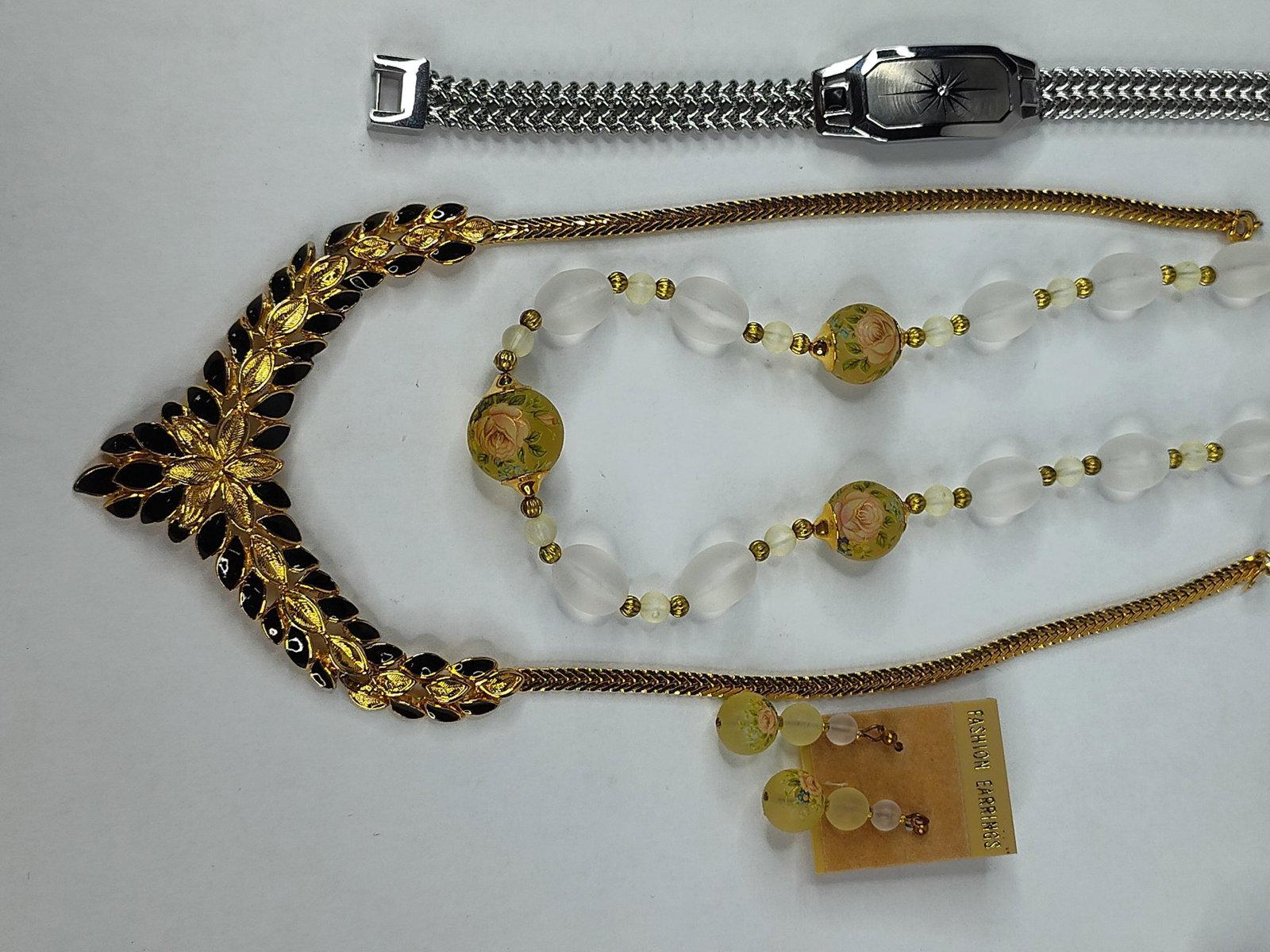 Trifari Necklace & Bradford Bracelet: This collection features a designer necklace, a beaded jewelry set, and a boxed commemorative bracelet. The first piece is a Crown Trifari V-shaped bib necklace constructed of gold-tone base metal