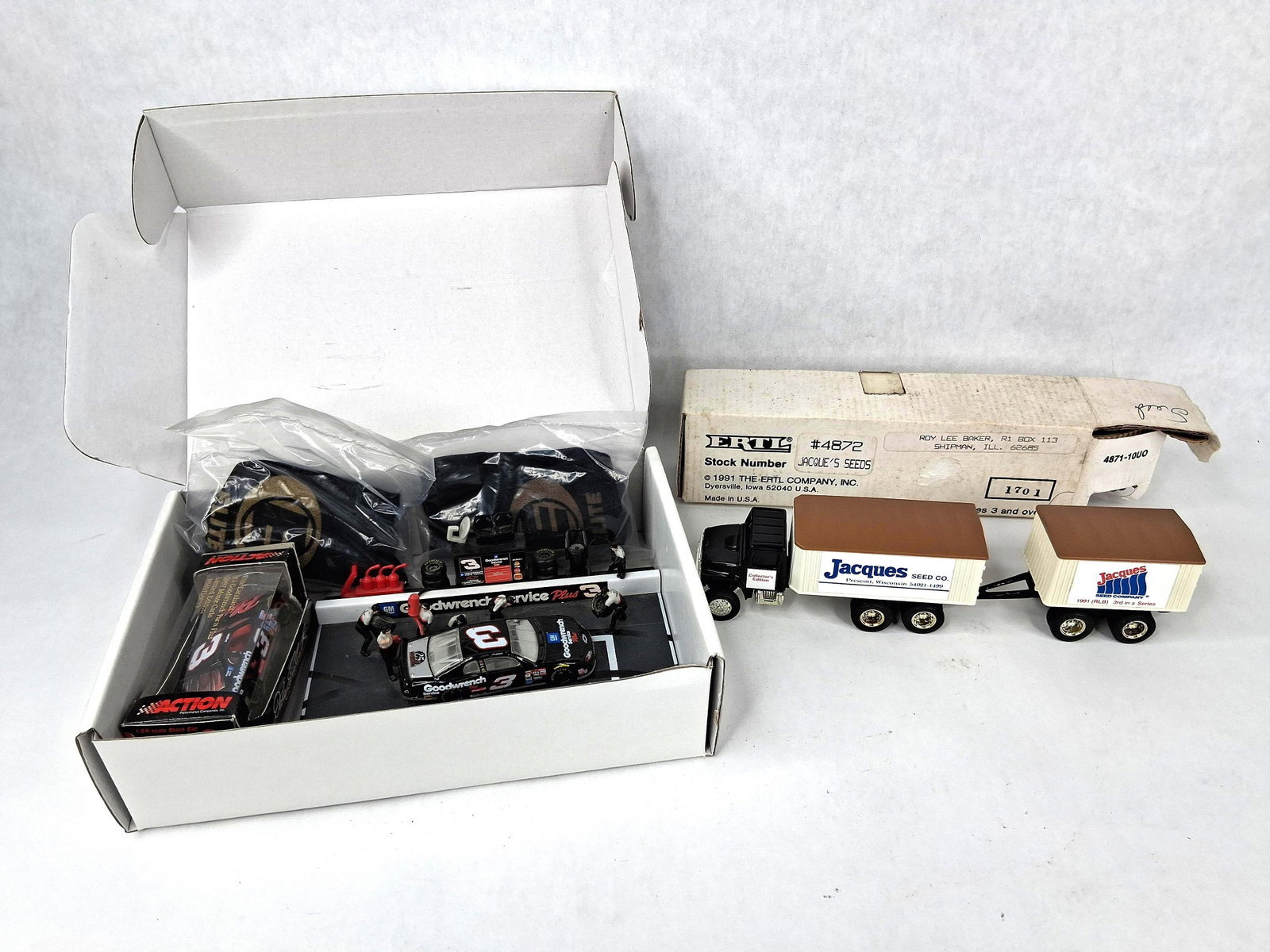 Ertl & Action Die-Cast & Earnhardt Mem: A collection of die-cast and plastic collectible toys featuring a promotional truck from Ertl and a NASCAR commemorative set from Action Performance Companies, Inc. The Ertl promotional set includes
