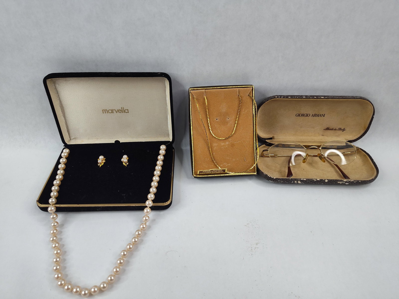 Marvella Pearl, Chain & Brooks Glasses: This lot consists of three separate fashion accessories. The first is a Marvella brand simulated pearl jewelry set comprising a single strand necklace of uniform cream-colored pearls with a gold-tone 