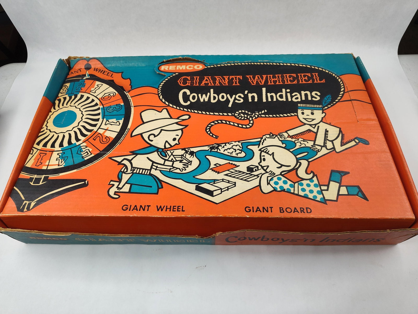 1958 Remco Cowboys & Indians Board Game: Remco Industries, Inc. Giant Wheel Cowboys 'n Indians board game, style number 803, manufactured in 1958. The set includes a large red plastic hand-operated spinning wheel with numbered segments and g