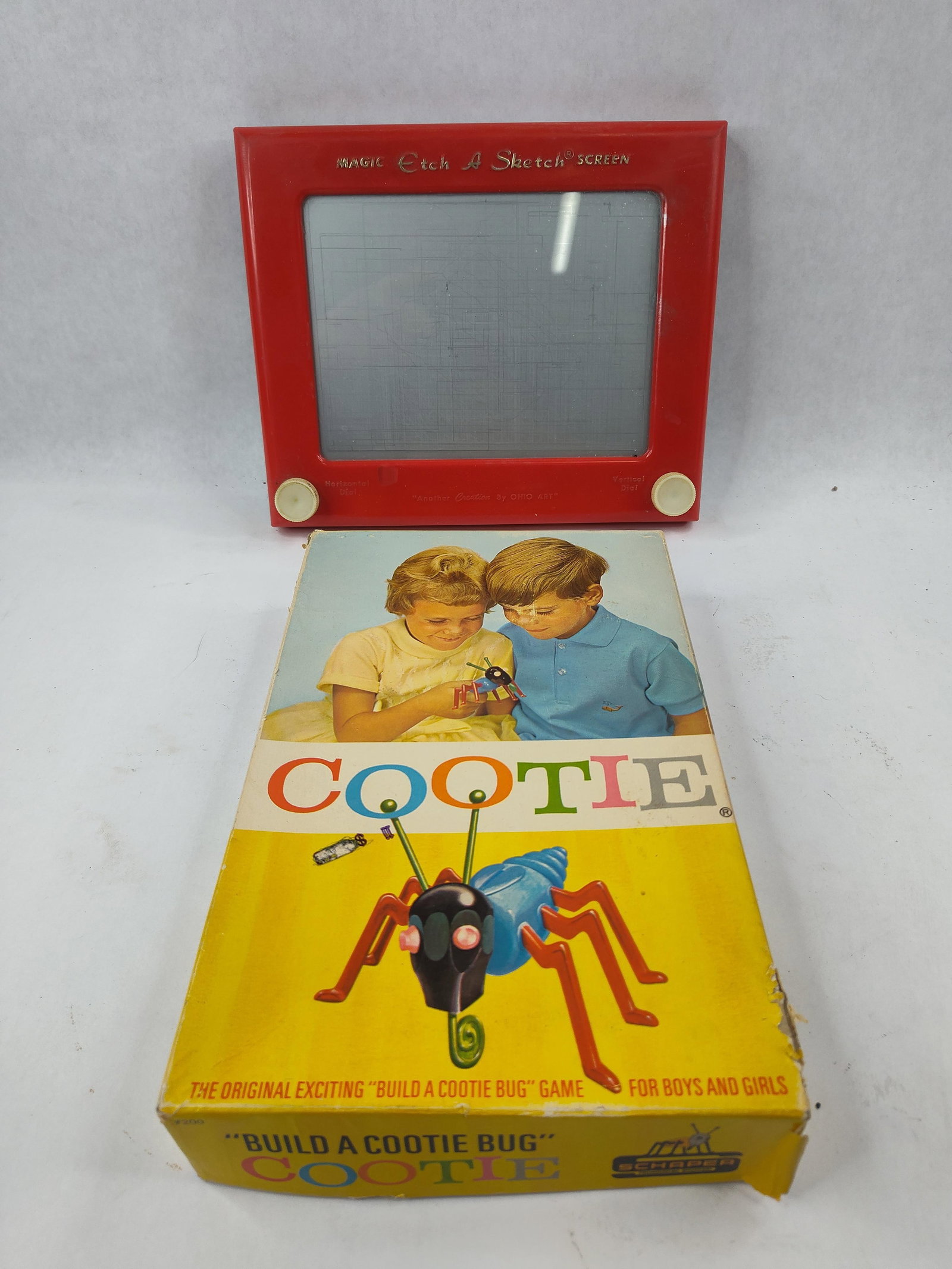 Ohio Art Etch A Sketch & Schaper Cootie: This lot includes two classic mid-century American toys. The first is a Magic Etch A Sketch Screen No. 505 manufactured by the Ohio Art Company in Bryan, Ohio. It is constructed with a red plastic fra