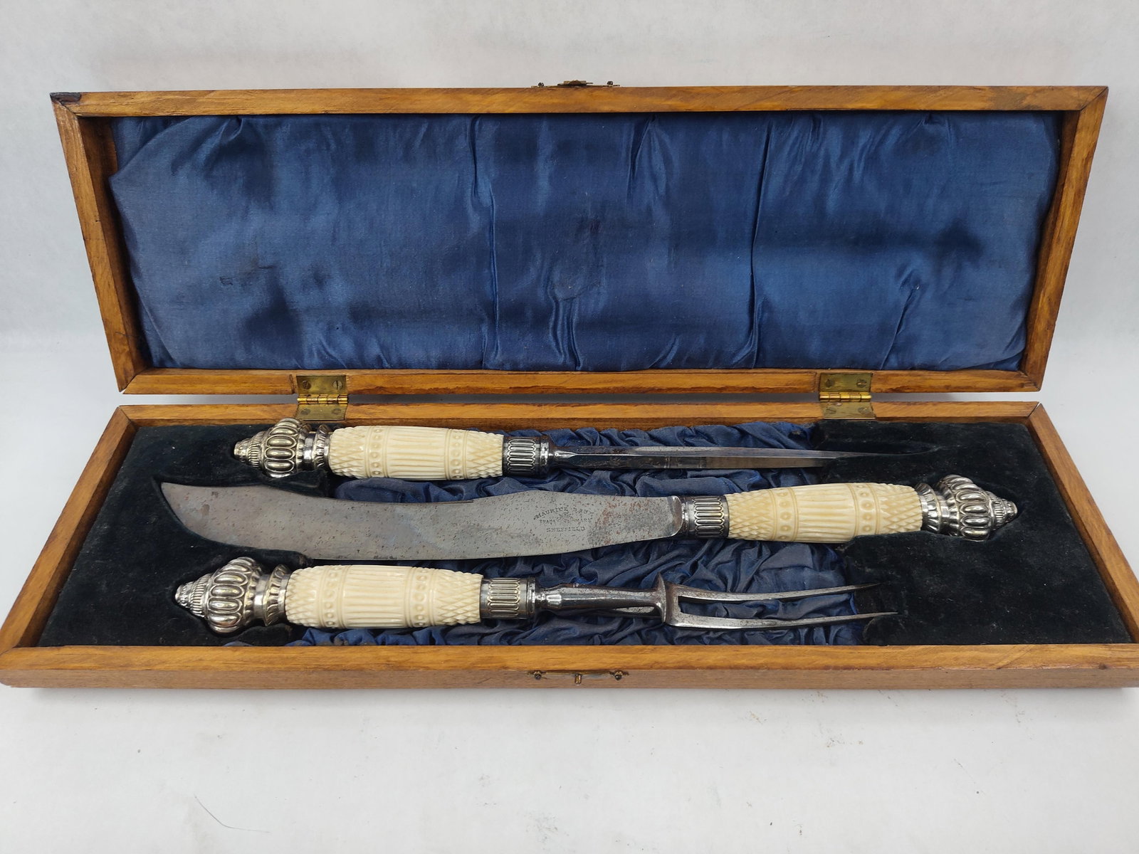 M. Baum Sheffield 3pc Ivory Carving Set: A three piece Victorian style carving set manufactured by Maurice Baum of Sheffield, England, comprising a carving knife, carving fork, and sharpening steel. The handles are constructed of carved ivor
