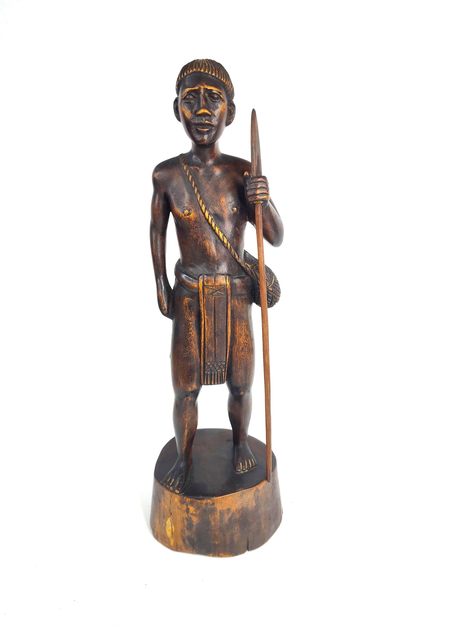 Igorot Kamagong Wood Hunter Figure: This hand-carved wooden figure depicts an indigenous male hunter or warrior from the Igorot/Cordillera peoples of the Philippines. The figure stands in a relaxed posture on an integral circular base