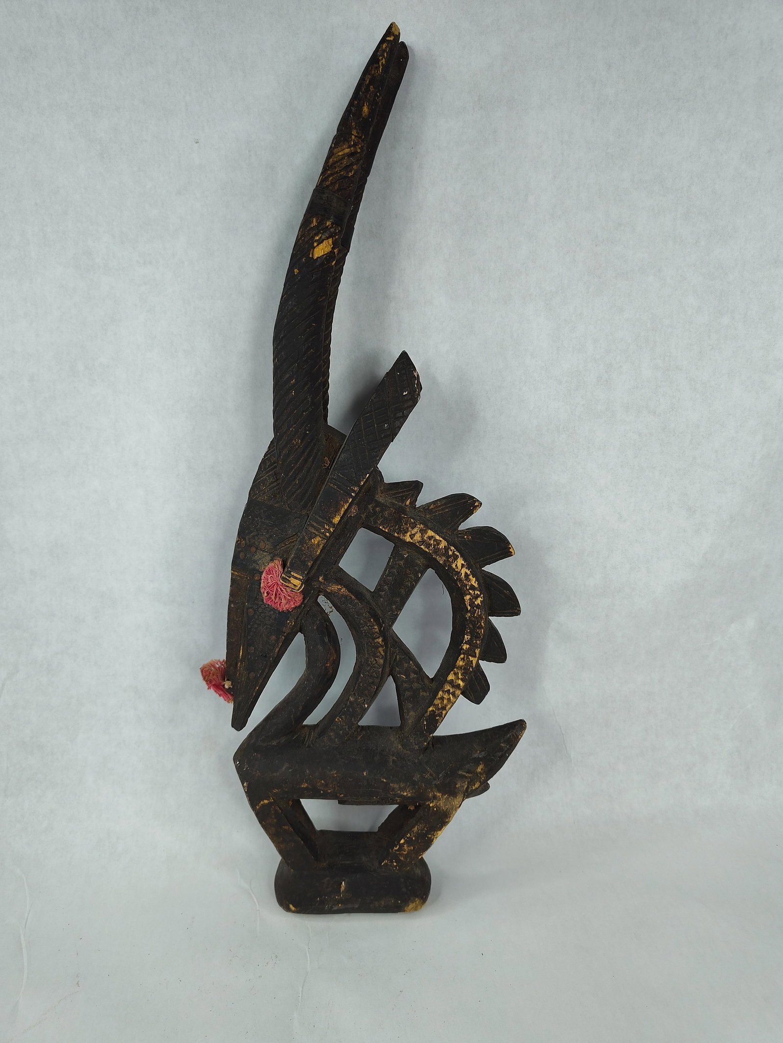 Bamana Ciwara Vertical Antelope, Mali: A Bamana Ciwara (Chi Wara) antelope headdress sculpture from Mali. This vertical-style crest is hand-carved from a single piece of dark hardwood. The sculpture depicts a stylized antelope