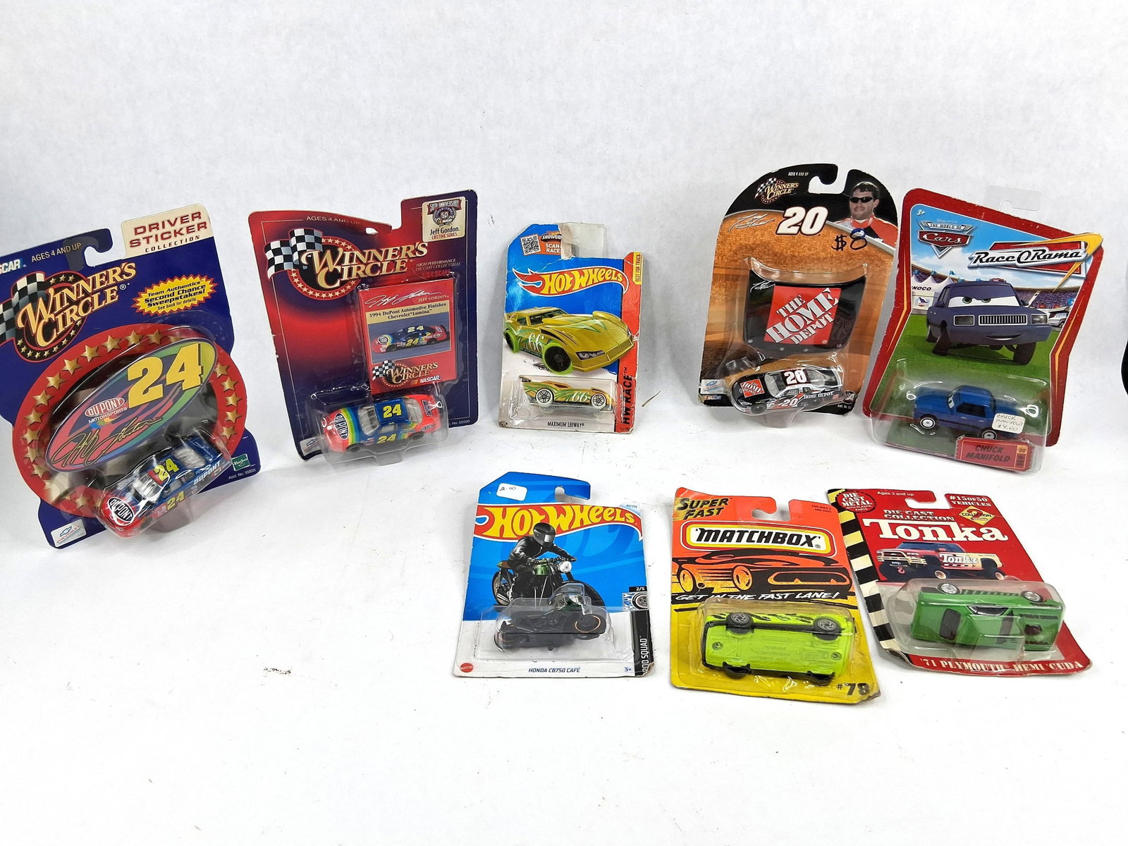 8 Die-Cast NASCAR, Matchbox, Hot Wheels: An assortment of eight collectible toy vehicles, including one motorcycle, each factory-sealed in its original blister pack. This collection features a variety of manufacturers including Winner's Circ