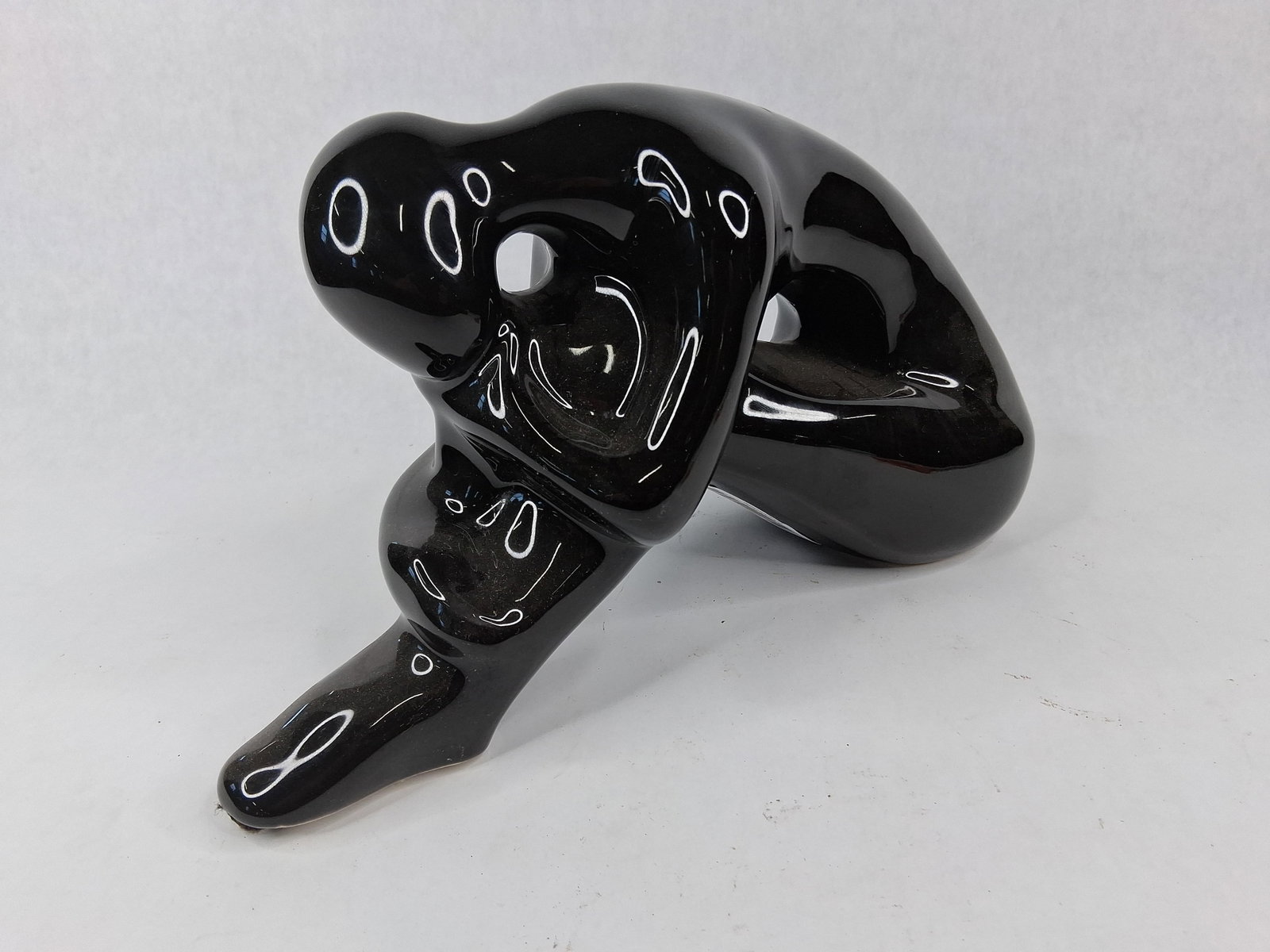 Royal Haeger Pondering Woman Sculpture: A mid-century modern abstract figurative sculpture by Royal Haeger, specifically the design known as the Pondering Woman. This piece is crafted from ceramic and finished in a deep, high-gloss black gl