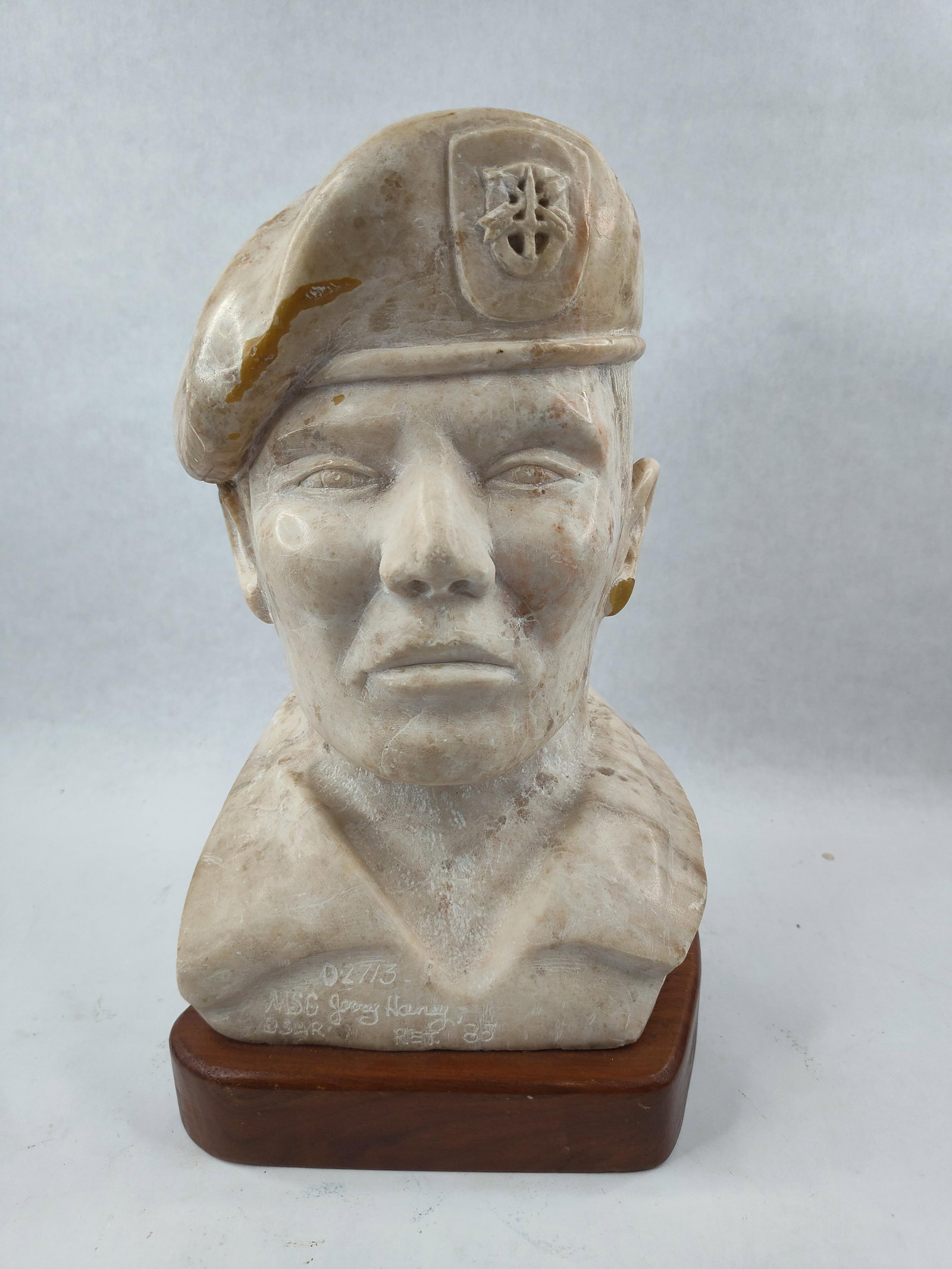 Stone Bust: MSG Jerry Haney, 1985: A hand-carved stone sculptural bust depicting a United States Army Special Forces soldier, identified by inscription as Master Sergeant Jerry Haney. The figure is portrayed wearing a military beret fe
