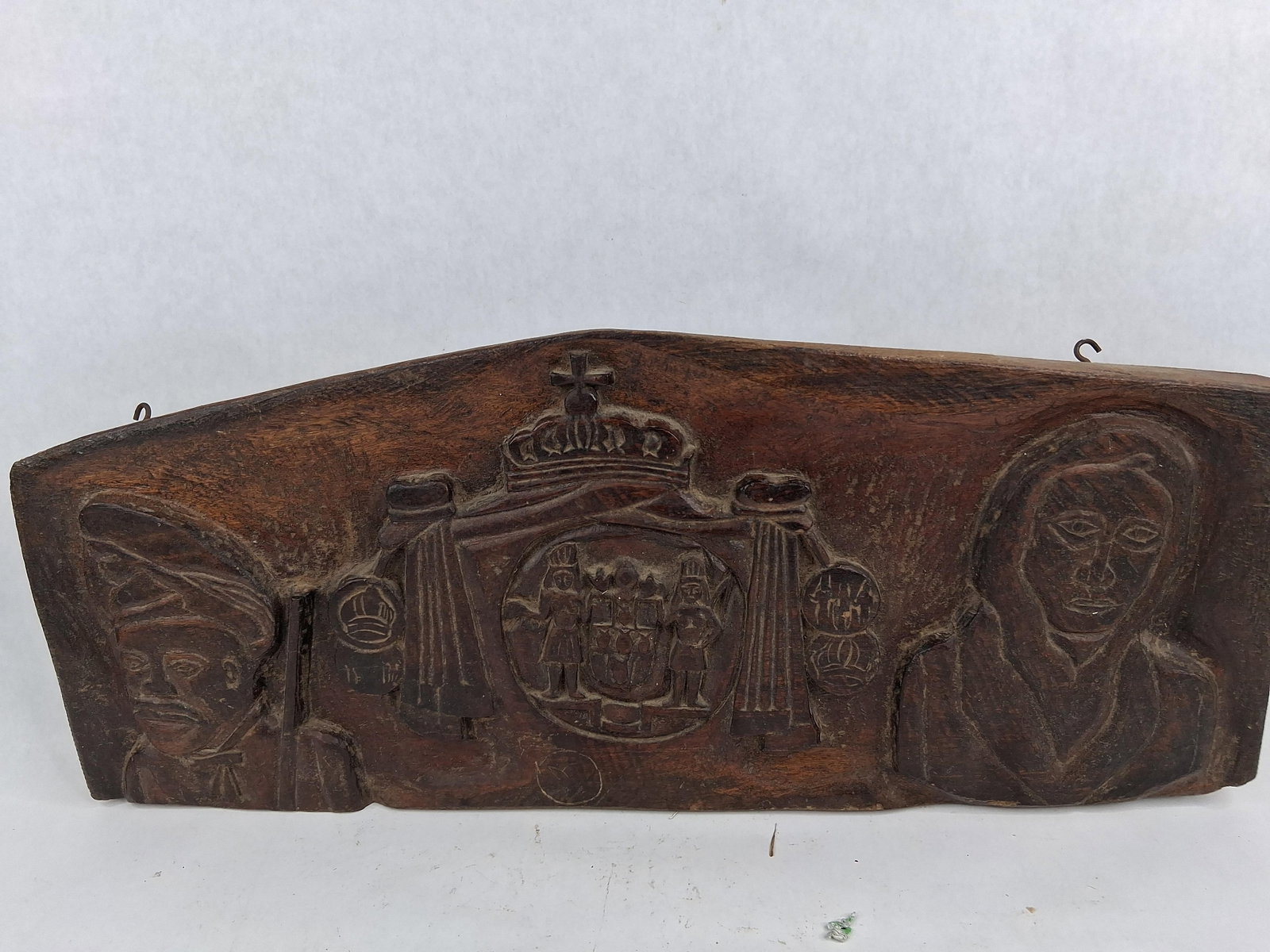 European Wood Relief: Heraldic/Portrait: A hand-carved hardwood relief plaque featuring a central coat of arms within a circular medallion supported by two standing figures. The central motif is surmounted by a draped canopy and a royal crow