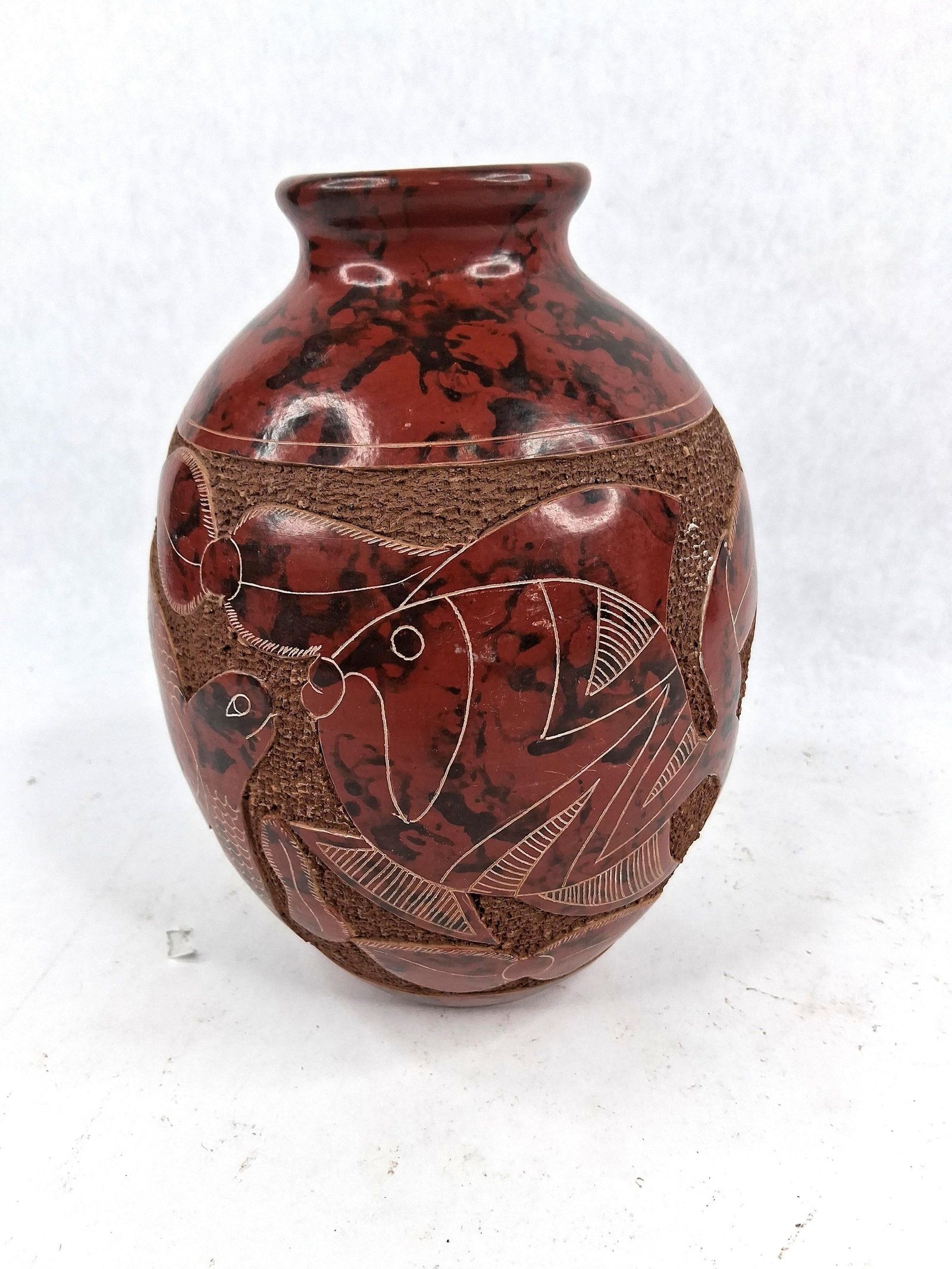 San Juan de Oriente Sgraffito Fish Vase: A hand-thrown ceramic vase originating from San Juan de Oriente, Nicaragua, featuring intricate sgraffito decoration. The vessel is constructed with a rounded ovoid body and a short, flared rim. The s