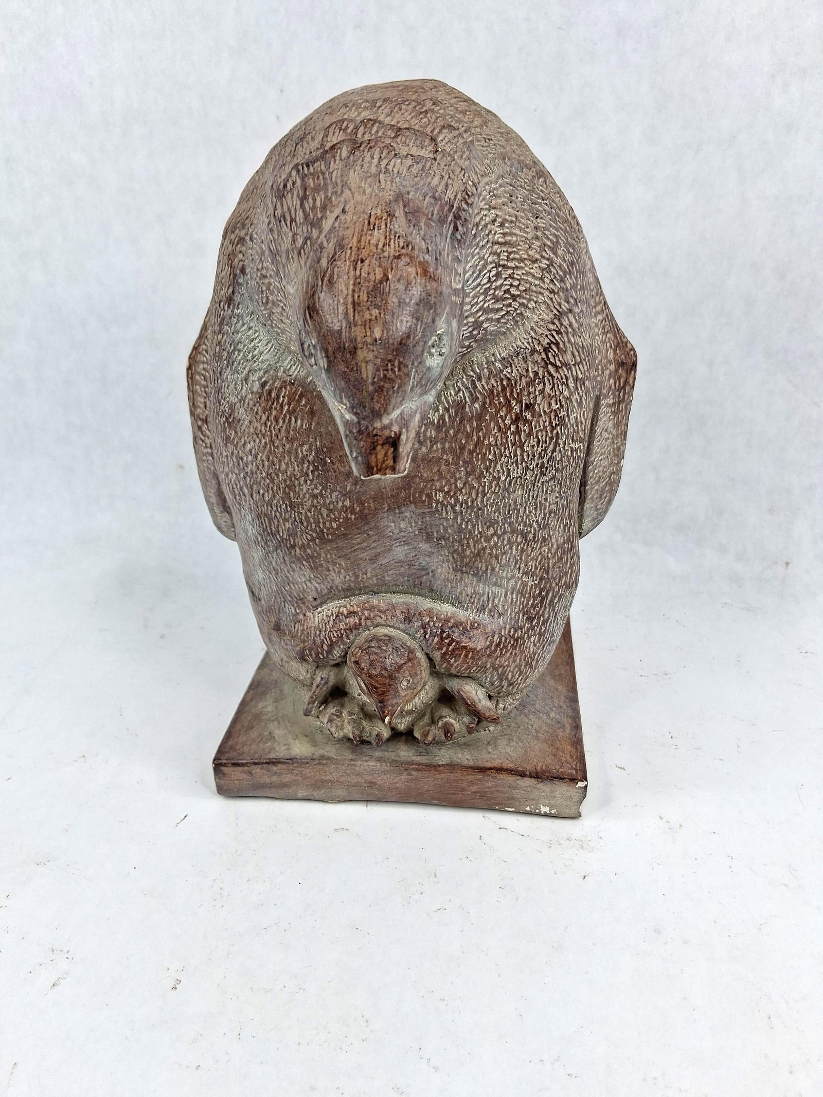 Composite Penguin & Chick Sculpture: A cast composite sculpture depicting an adult penguin in a naturalistic brooding posture over a single chick nestled at its feet. The work features a highly textured surface intended to simulate the