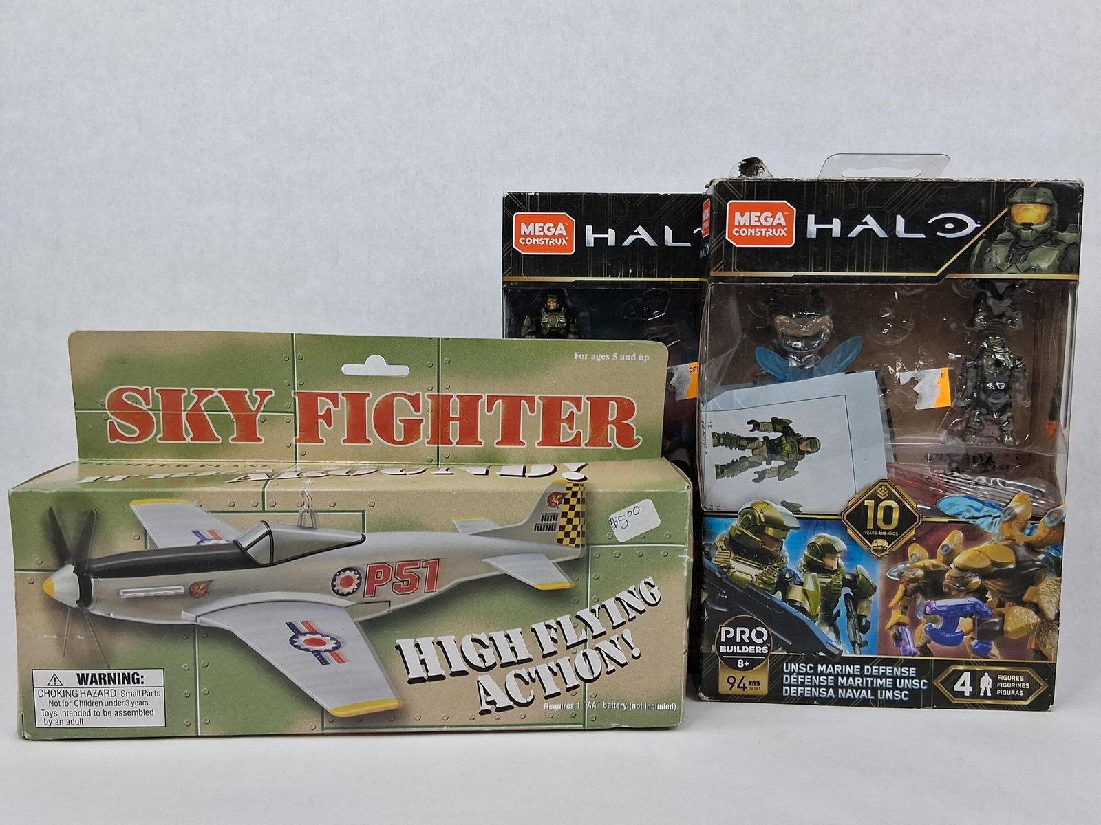 2), Halo (3), Sky Fighter (3): This lot features three collectible toy items in their original packaging. The first item is a Dah Yang Toy Industrial Co., Ltd. Sky Fighter battery-operated airplane modeled after the P-51 Mustang.