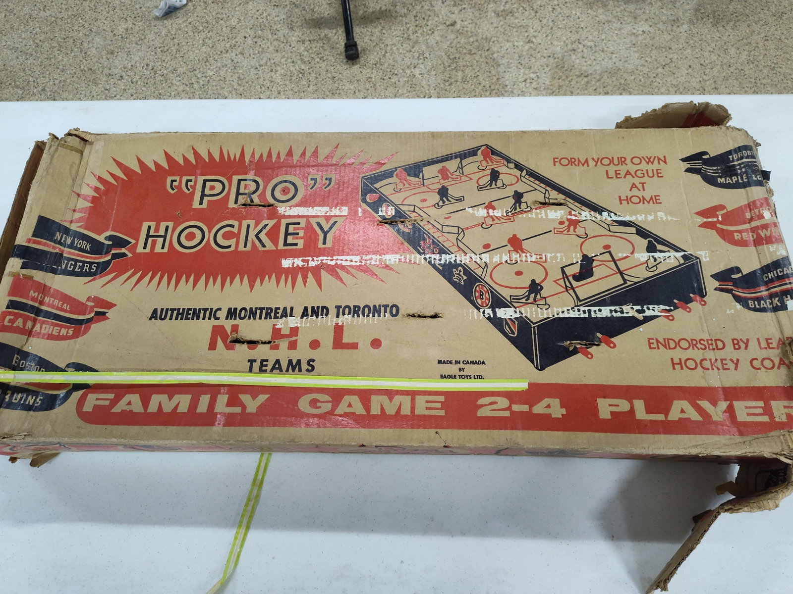1957 Eagle Toys Pro Hockey Game w/ Box: This is a Pro Hockey tabletop rod hockey game manufactured by Eagle Toys Ltd. of Canada. The game features a lithographed tin-litho rink surface with official N.H.L. branding. The player figures are