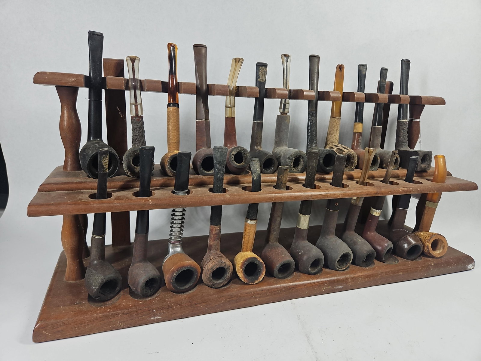 Vtg Estate Tobacco Pipes & Wood Rack: An assortment of vintage estate tobacco pipes presented on a two-tier wooden storage rack. The collection features a variety of shapes including billiards, Dublins, and pokers, alongside one metal