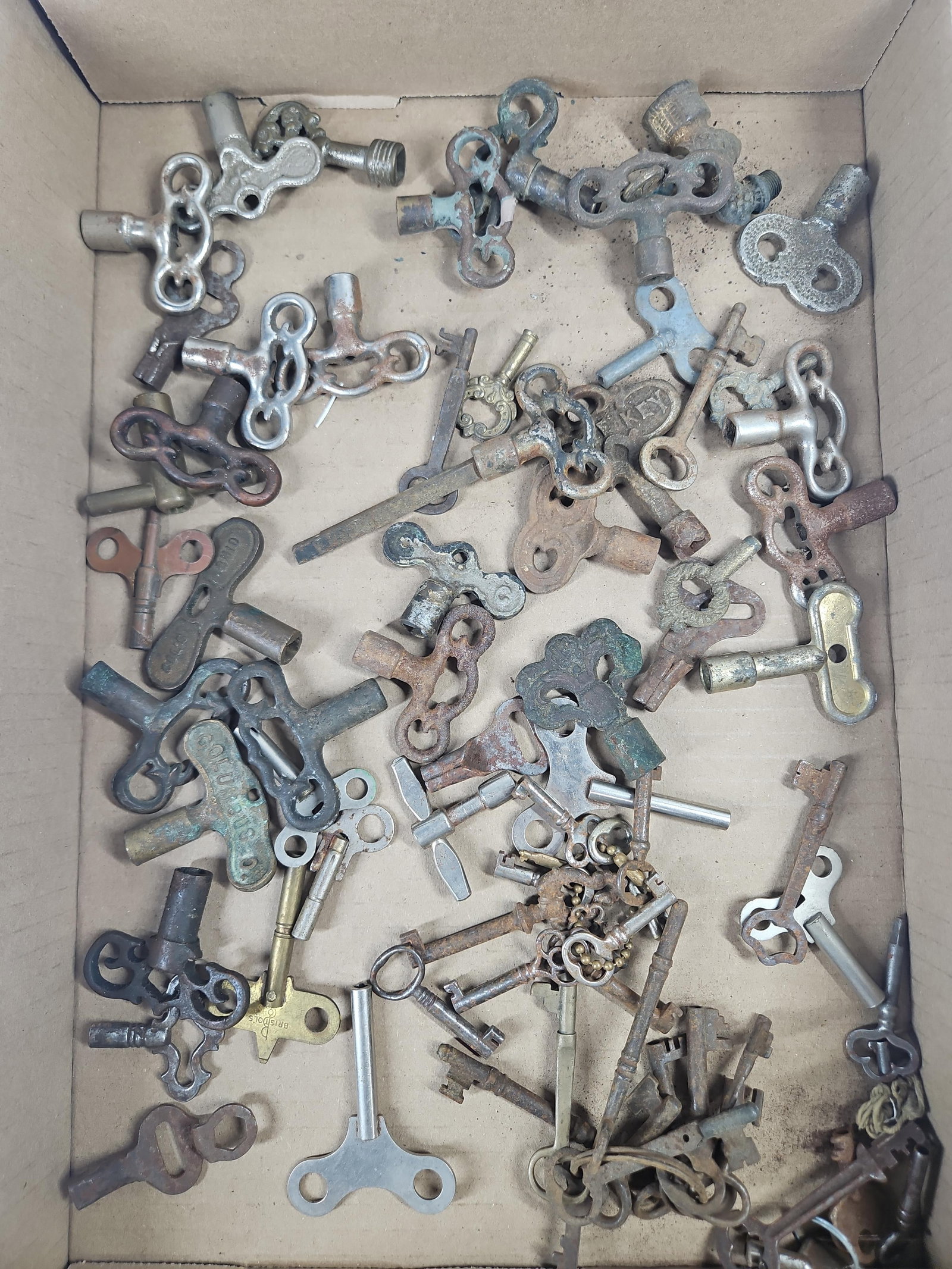 60+ Antique & Vtg Clock & Skeleton Keys: This is an assortment of approximately 60 to 70 antique and vintage winding and skeleton keys, including examples from the Victorian period through the early 20th century. The collection features a va