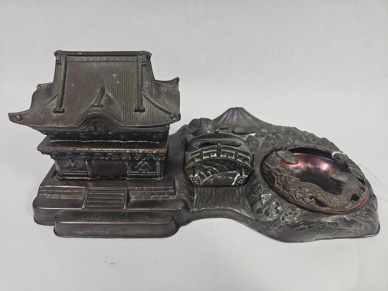 Japanese Metal Landscape Smoking Set: This set is constructed from cast patinated non-ferrous metal and depicts a traditional Japanese landscape. The primary base is cast in high relief to show a mountainous scene including Mt. Fuji,