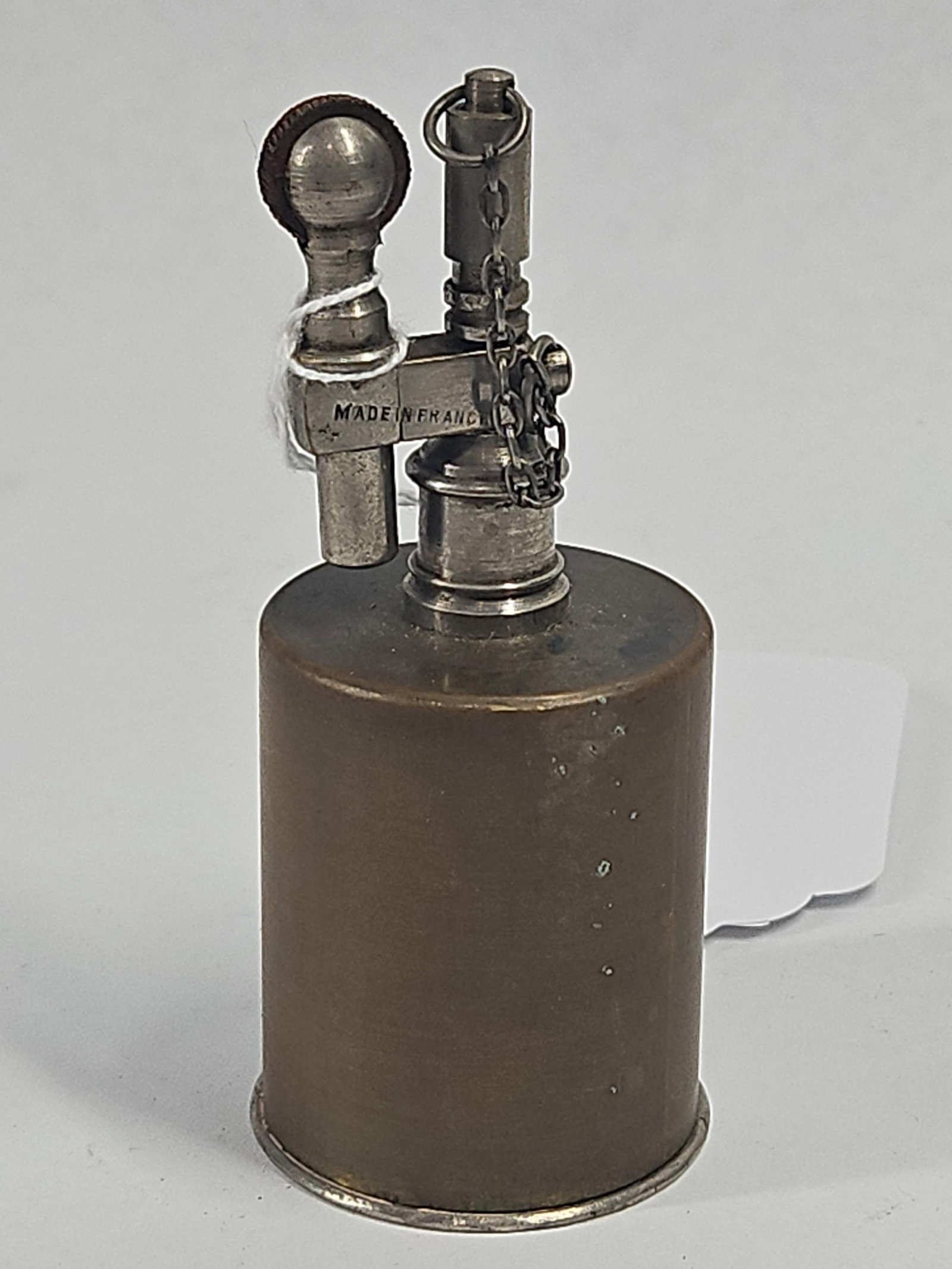 French Brass/Silver Metal Table Lighter: A French petrol lighter featuring a cylindrical brass fuel reservoir set between a silver toned metal base and top mechanism. The upper assembly includes a vertical wick tube equipped with a screw on