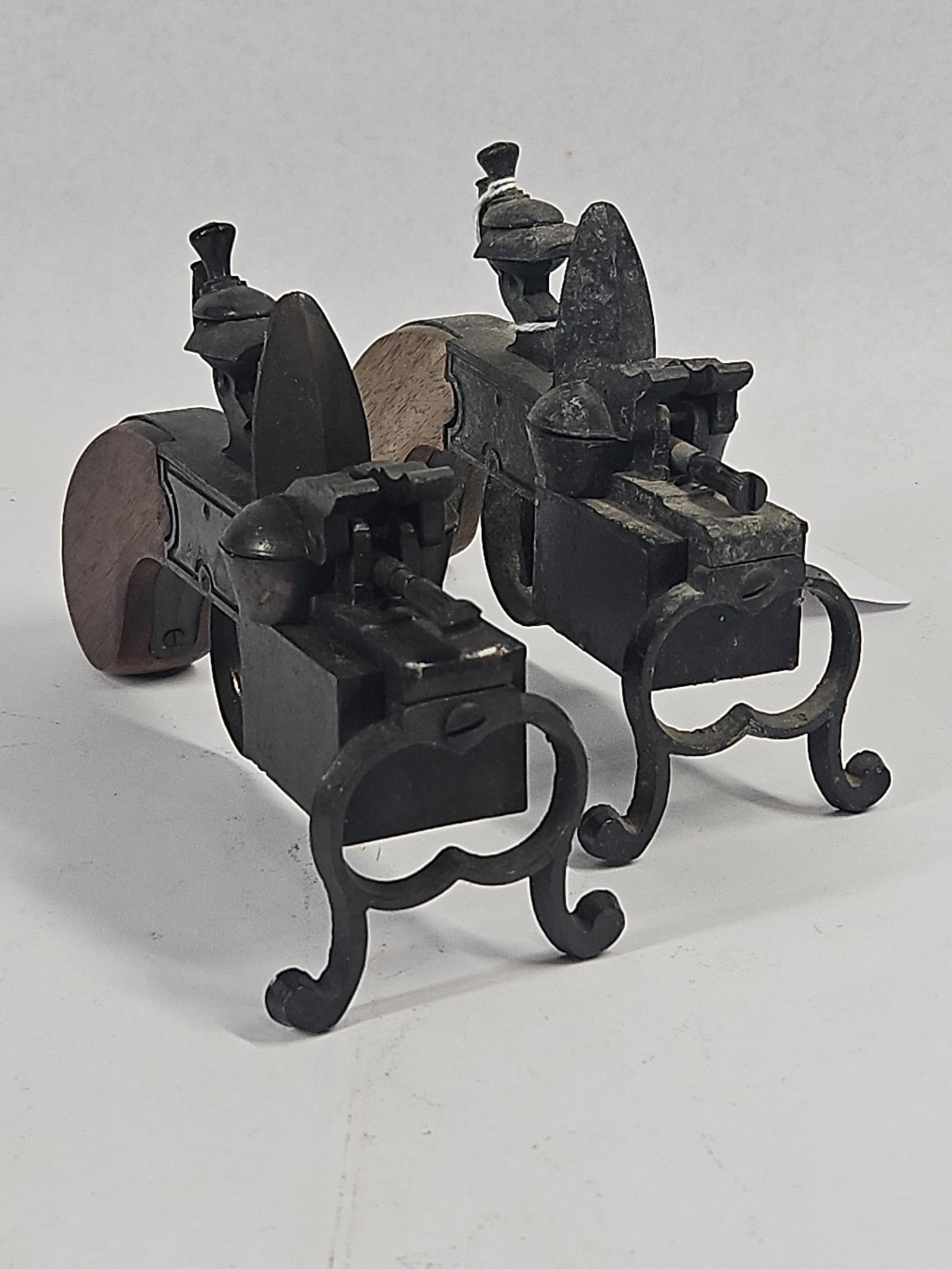 Pair Flintlock Tinder Pistol Lighters: A pair of vintage cast metal table lighters modeled after 18th-century flintlock tinder pistols. Each piece is constructed with a dark-patinated cast metal body and features wooden grip scales. The