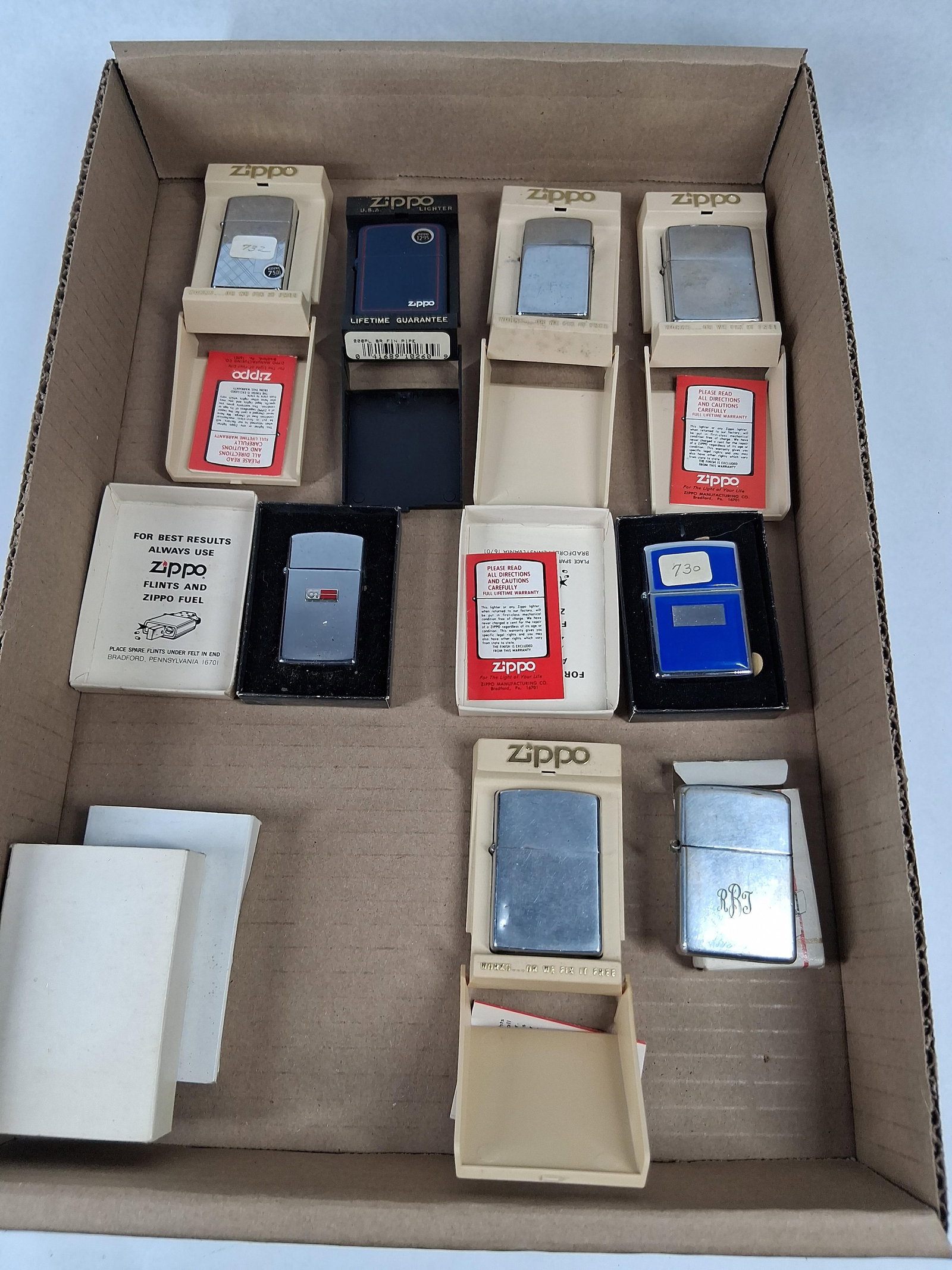 Zippo Lighters & Advertising Models: A collection of Zippo pocket lighters in various finishes including brushed chrome, polished chrome, and matte blue. The collection features several distinct models including a matte blue pipe lighter