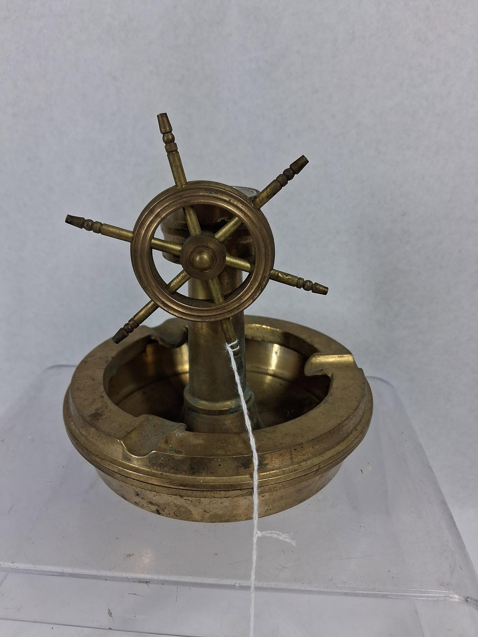 Taiwanese Brass Wheel Binnacle Ashtray: A Taiwanese cast brass nautical themed desk accessory featuring a combined ashtray, miniature binnacle, and compass. The circular base functions as an ashtray with three integrated cigarette rests