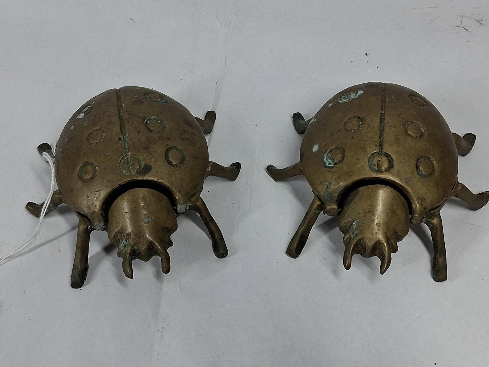 Pair Cast Brass Beetle Lidded Ashtrays: A pair of vintage cast brass ashtrays modeled in the form of stylized beetles, likely ladybugs or scarabs. Each piece features a rounded, segmented body with six protruding legs and a head cast with