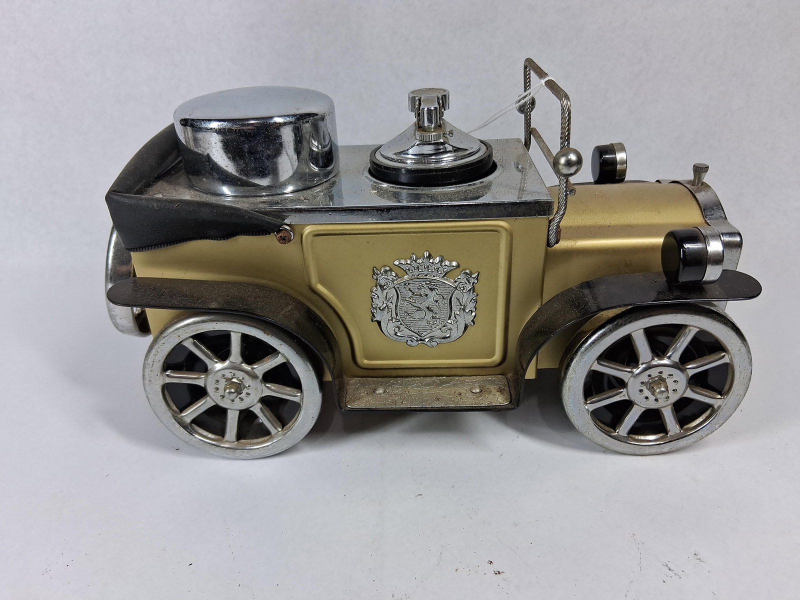Vtg Gold Metal Car Lighter & Holder: This vintage novelty table lighter and desk accessory is designed in the form of an early 20th-century open touring car. The item features a cast metal body with a gold-toned finish, black enameled