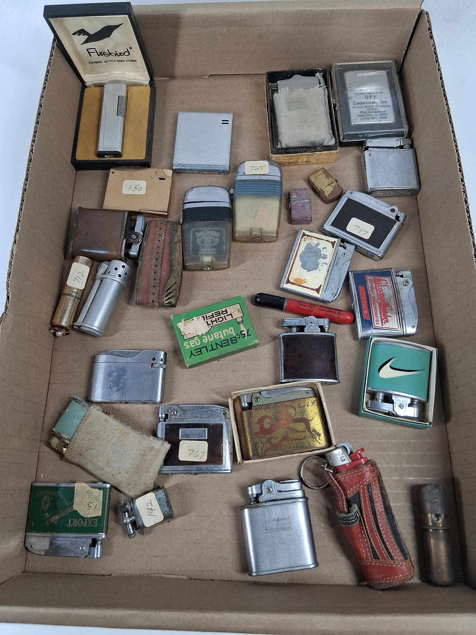 Firebird, Elgin, Omega, Hadson Lighters: This lot features an assortment of vintage pocket lighters and related smoking accessories in various styles and materials, including chrome-plated metal, brass, plastic, leather, and cloth-wrapped