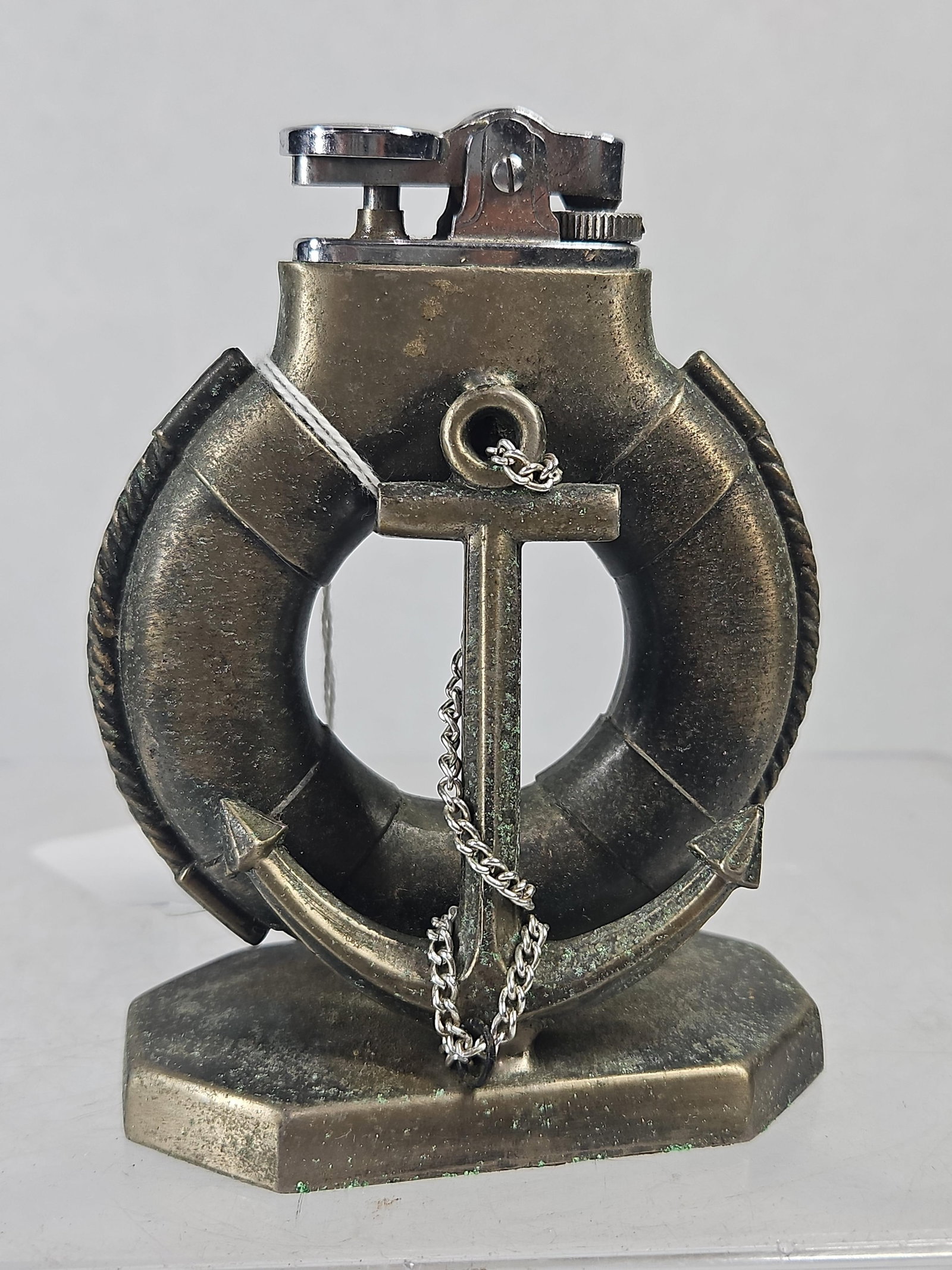 Japanese Metal Lifebuoy/Anchor Lighter: A Japanese vintage nautical-themed figural table lighter constructed from cast metal with an antiqued bronze-tone finish. The decorative body is shaped as a lifebuoy encircling a central anchor,