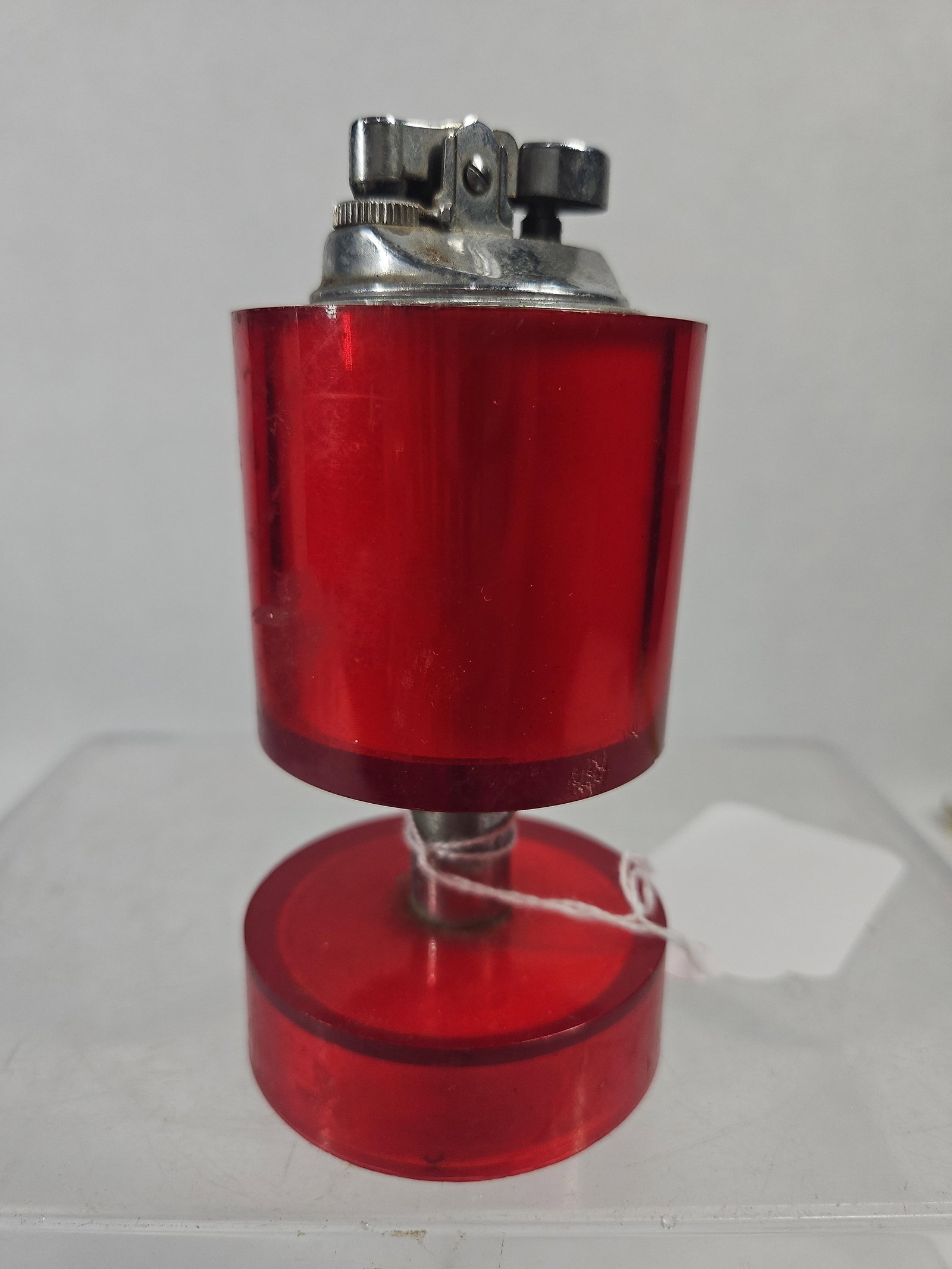 MCM Red Acrylic & Chrome Table Lighter: This Japanese mid-century modern table lighter features a tiered design composed of two translucent red acrylic cylinders connected by a central chrome-plated metal stem. The upper cylinder contains