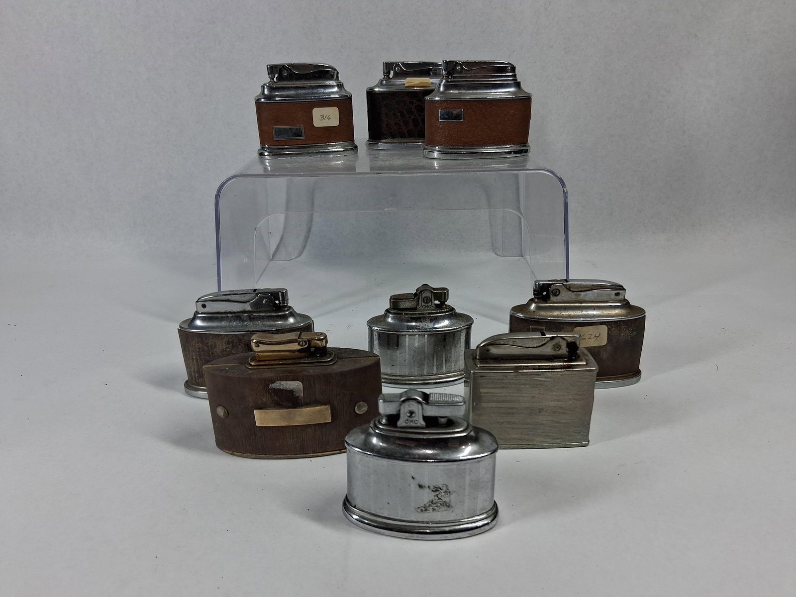 29)L(30)i(31)g(32)h(33)t(34)e(35)r(36)s: This assortment of mid-20th-century table lighters features several models manufactured by Ronson and various Japanese makers. The collection primarily consists of Ronson Senator models,