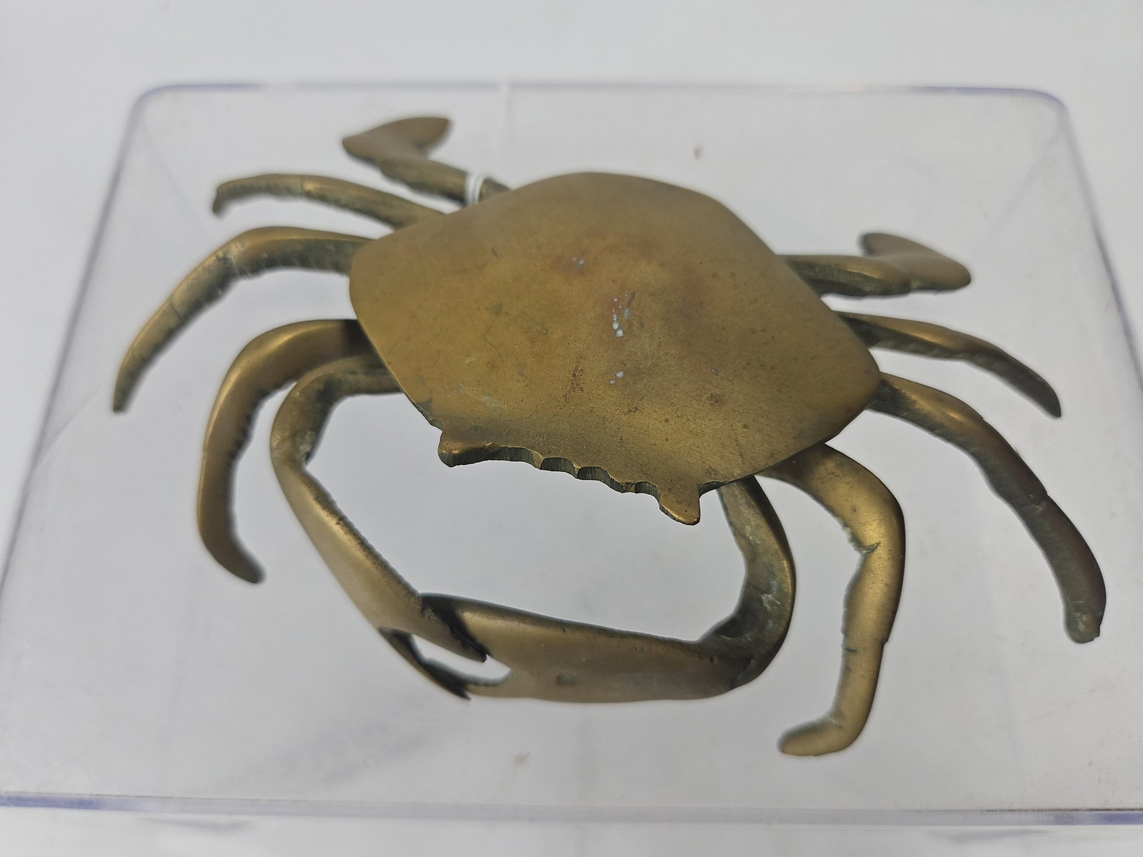 Vtg Cast Brass Hinged Crab Lidded Box: This is a vintage cast brass tabletop accessory modeled in the form of a crab. The piece is designed with a hinged top carapace that opens to reveal a shallow, circular interior chamber featuring a