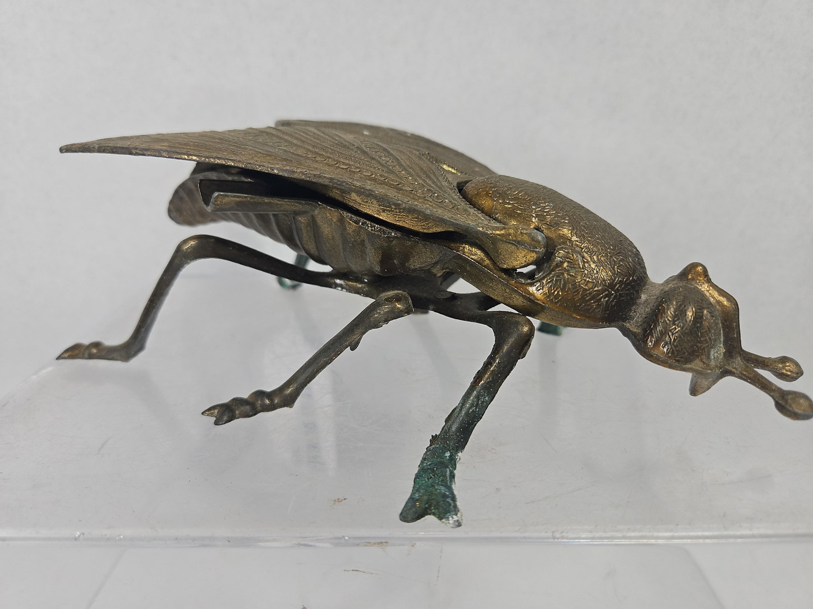 Italian Cast Brass Housefly Ashtray: An Italian cast brass ashtray in the form of a housefly. The piece is designed with a hinged wing assembly that opens to reveal a shallow interior compartment. Two flat, rectangular cigarette rests