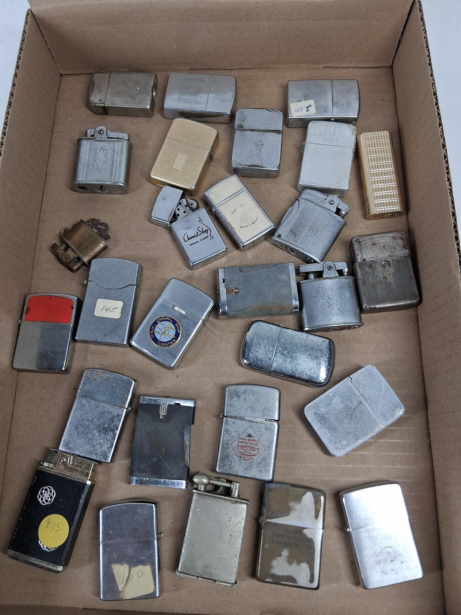27 Zippo, Ronson & Advertising Lighters: This is a collection of approximately 27 vintage cigarette lighters featuring a diverse array of manufacturers, mechanisms, and mid-century advertising graphics. The collection primarily consists of