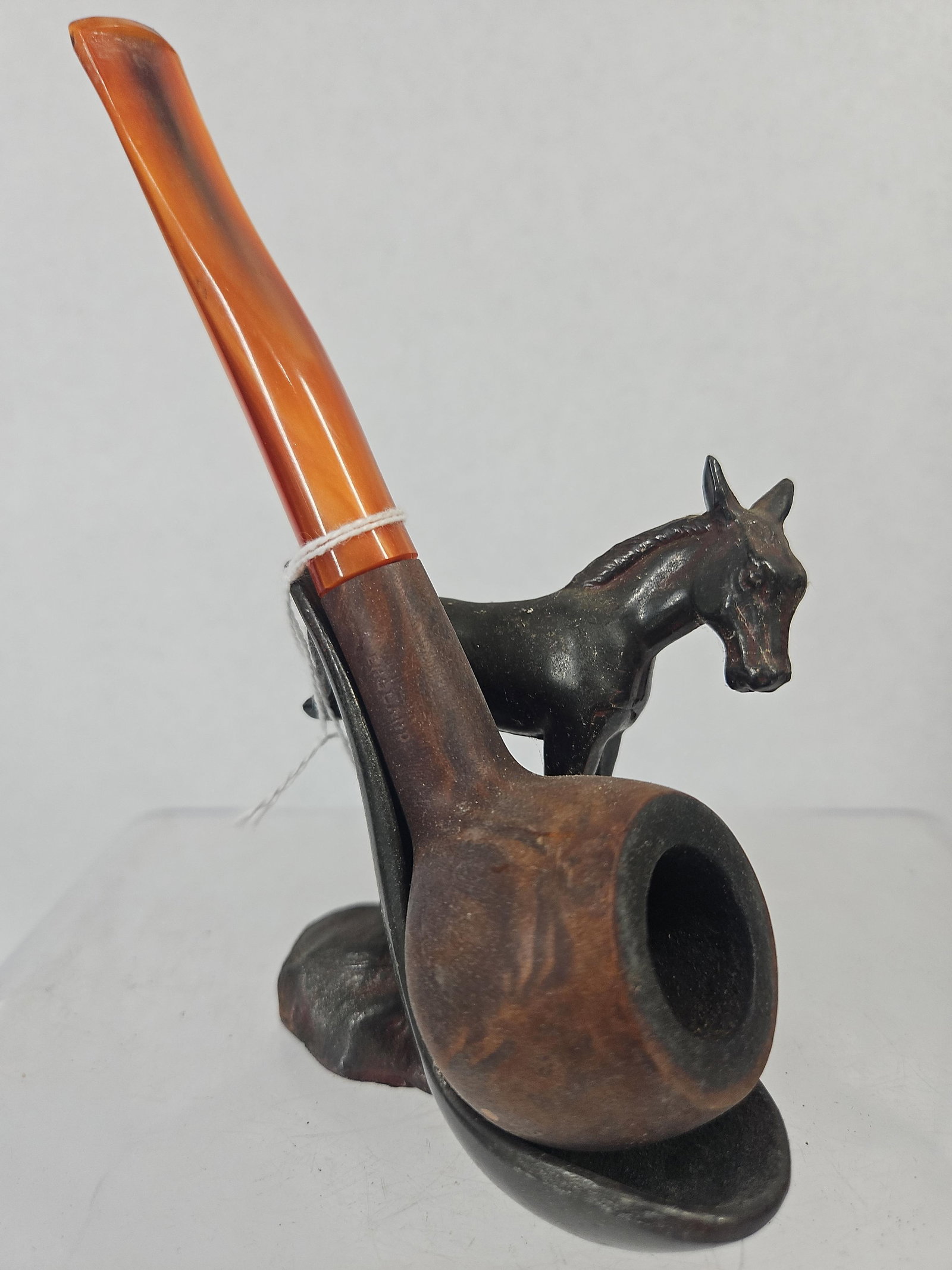 Vtg English Bruyere Pipe & Donkey Stand: An English smoking pipe and a figural cast metal pipe stand. The pipe is a billiard style crafted with a wooden bowl and a translucent, swirled orange and brown stem. The side of the shank features