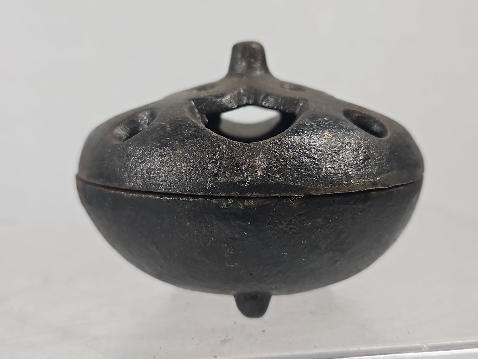 Japanese Patinated Bronze Tripod Koro: A 20th-century Japanese incense burner, or koro, of two-part globular construction cast from a dark-patinated copper alloy, likely bronze. The vessel consists of a bowl base resting on three small, in