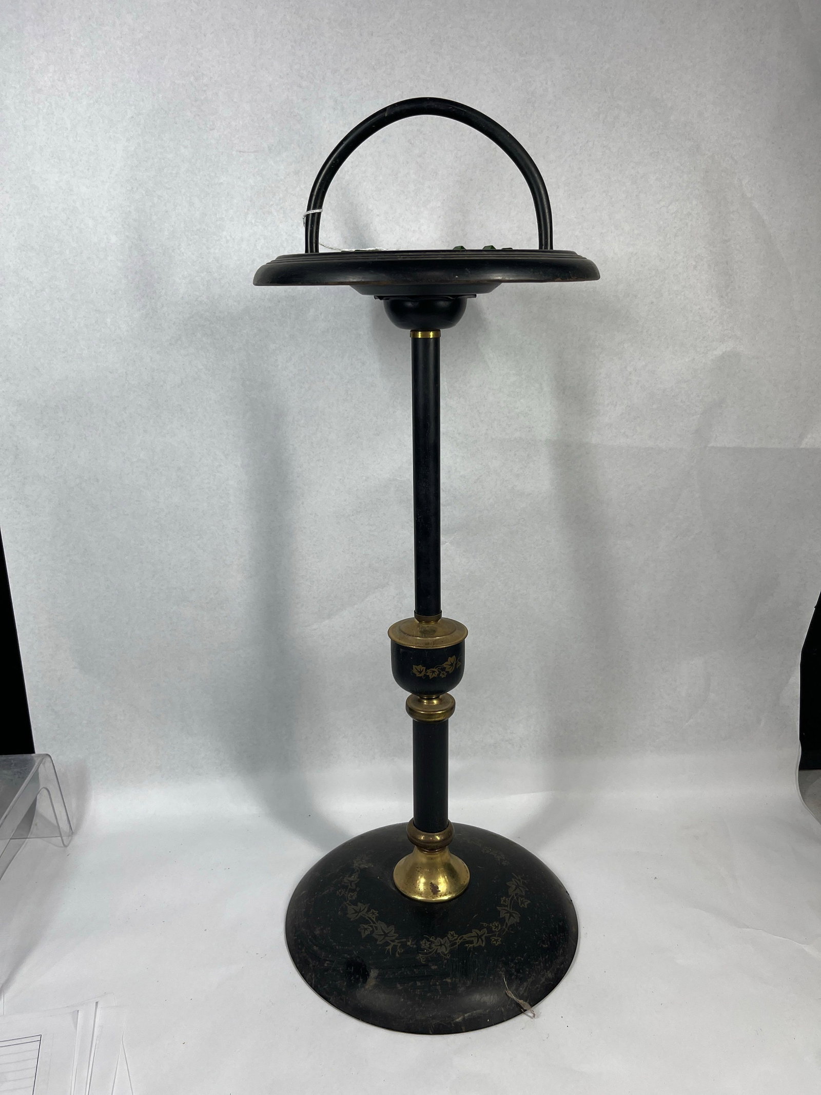 Art Deco Smoking Stand w/ Uranium Glass: An Art Deco floor-standing smoking stand constructed from black-painted metal with brass components. The stand features a weighted domed circular base leading to a vertical stem with a decorative